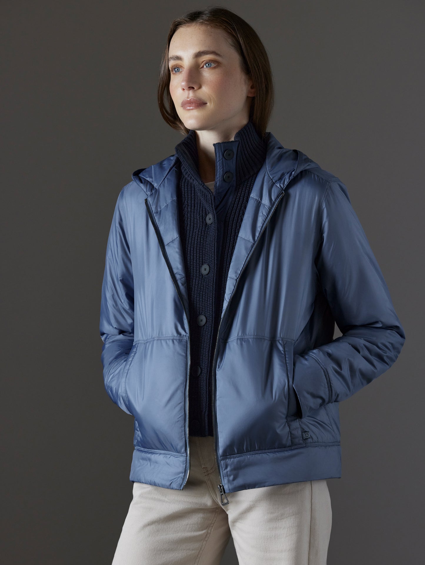 Front angled view of woman wearing Eco Space Hoodie in Portal Blue from AETHER Apparel.