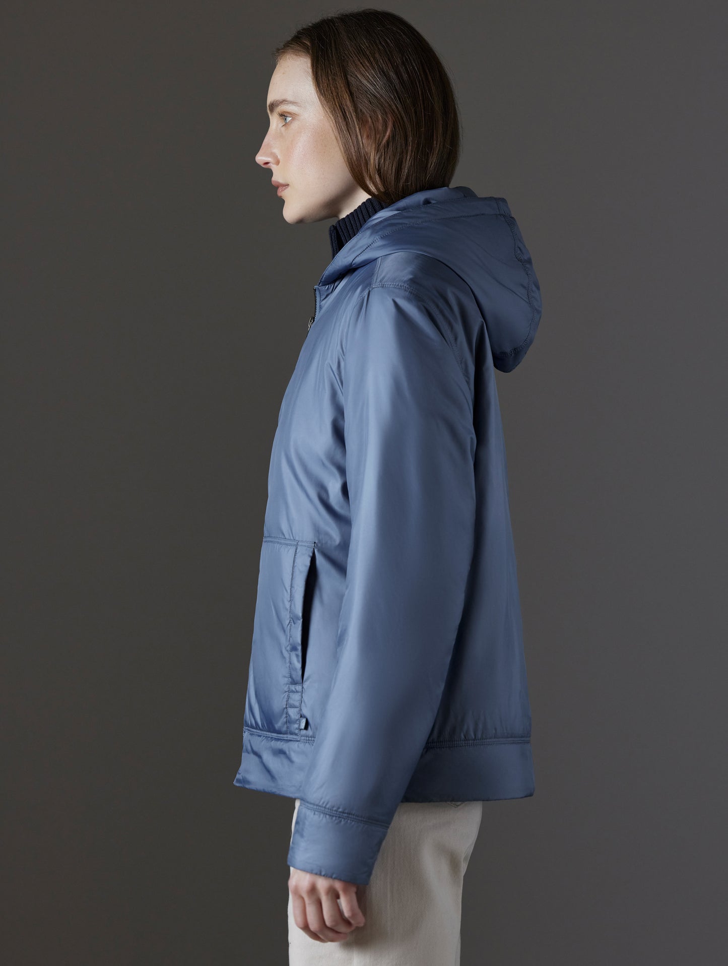 Side profile view of woman wearing Eco Space Hoodie in Portal Blue from AETHER Apparel.