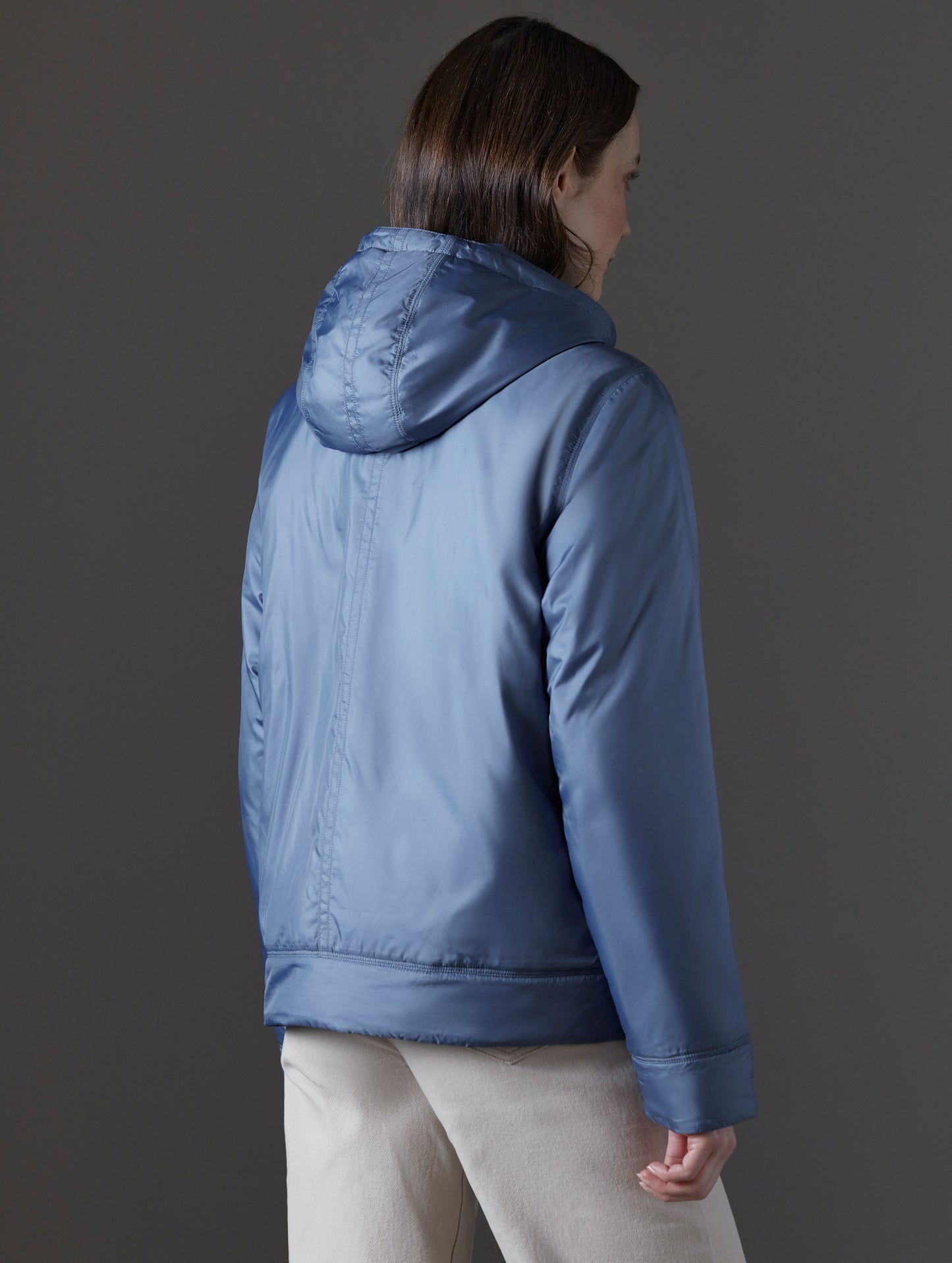 Rear angled view of woman wearing Eco Space Hoodie in Portal Blue from AETHER Apparel.