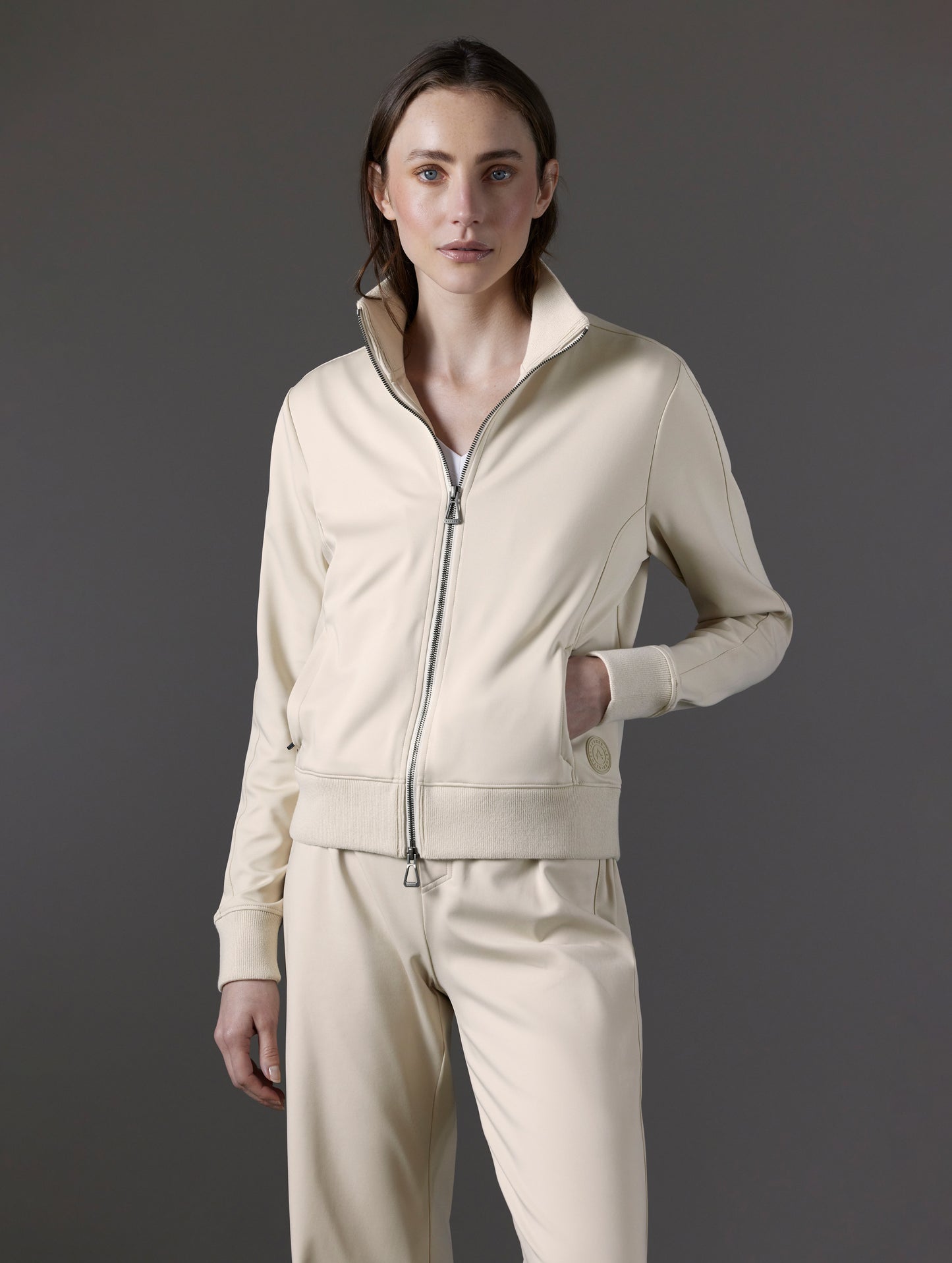 Front angled 3/4-body view of woman wearing Eloise Travel Jacket in Bone white from AETHER Apparel.