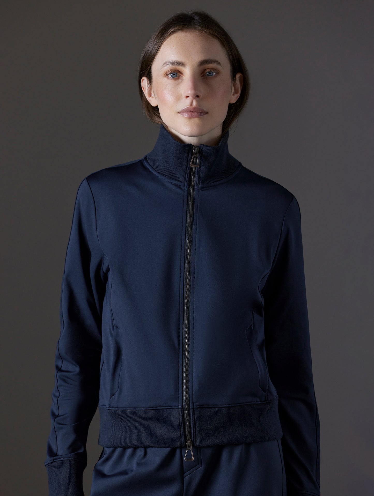 Front view of woman wearing Eloise Travel Jacket in Total Eclipse dark blue from AETHER Apparel.