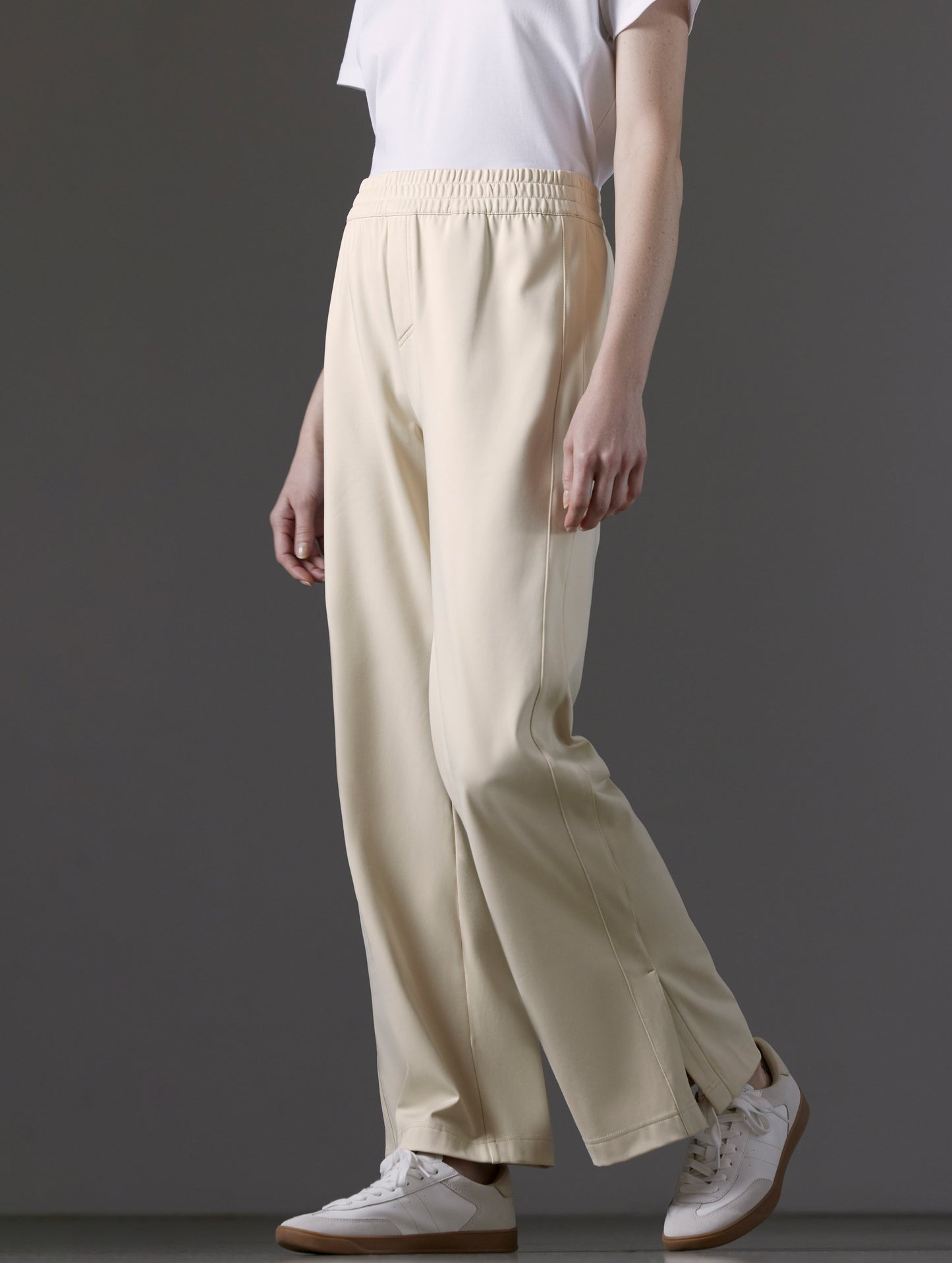 Front angled lower body view of woman wearing Eloise Travel Slim Pant in Bone white from AETHER Apparel.