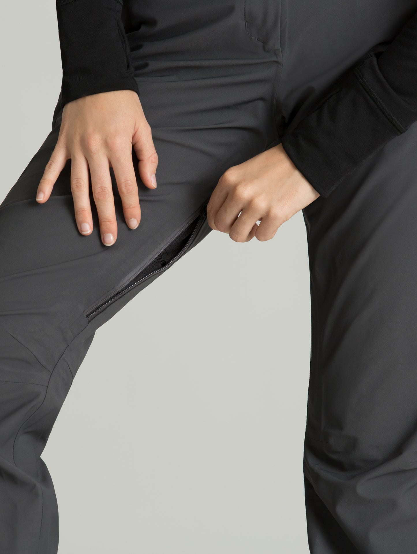 Woman wearing grey Forte Snow Pant from AETHER Apparel, displaying right inner thigh pocket.