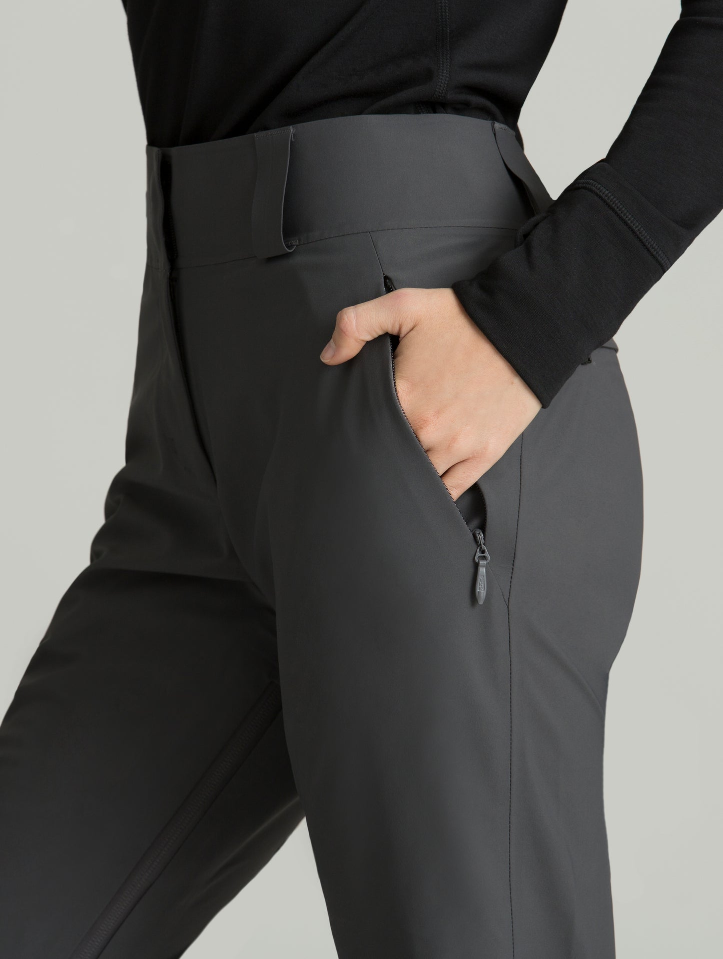 Woman wearing grey Forte Snow Pant from AETHER Apparel, closely displaying left pocket.