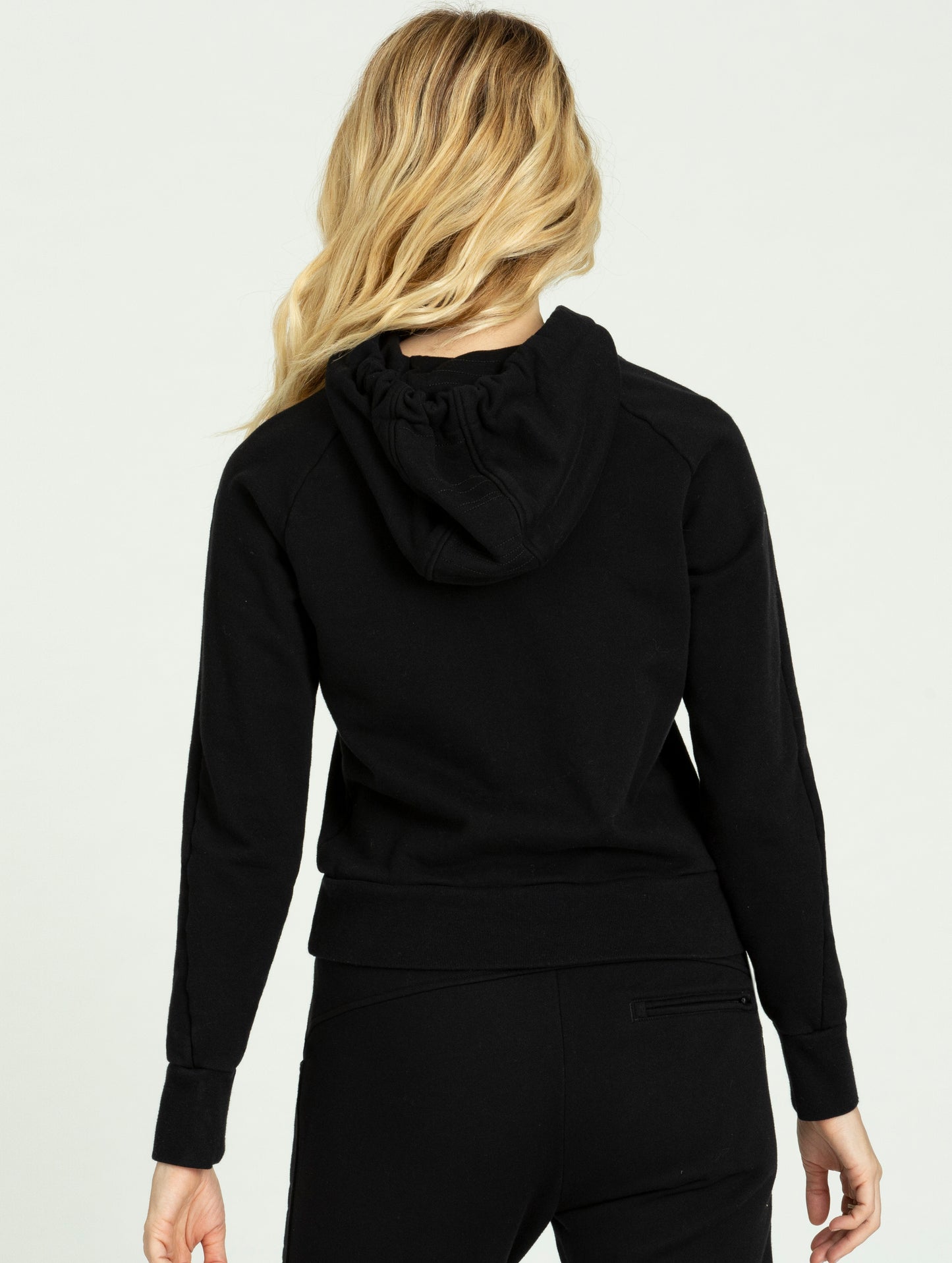 Back view of woman wearing black Journey Pullover from AETHER Apparel.