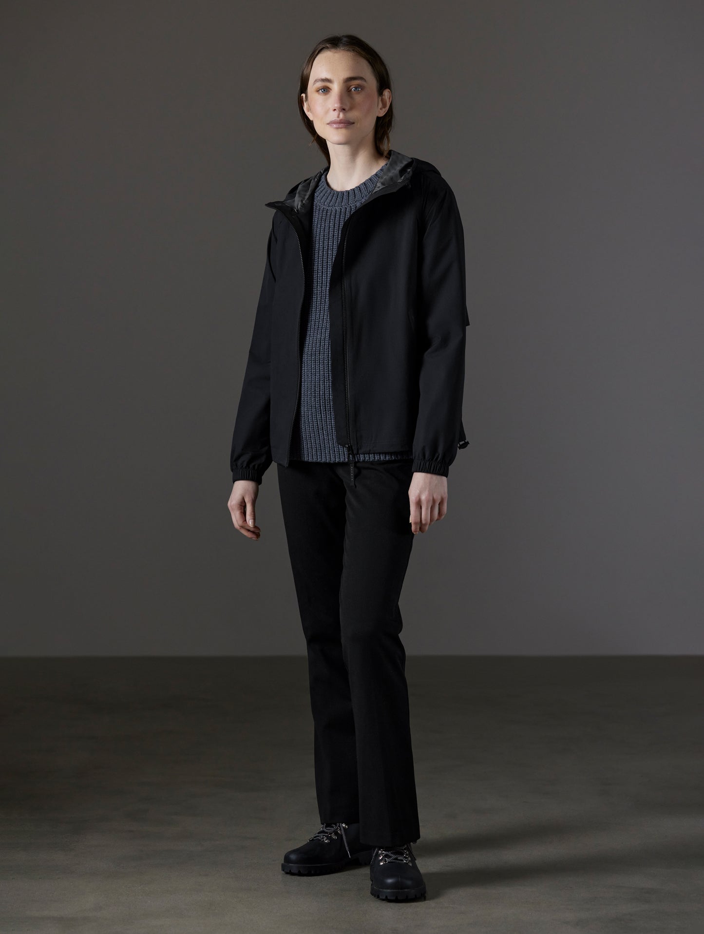 Front angled full-body view of woman wearing Kite Lightweight Jacket in Onyx Black from AETHER Apparel.