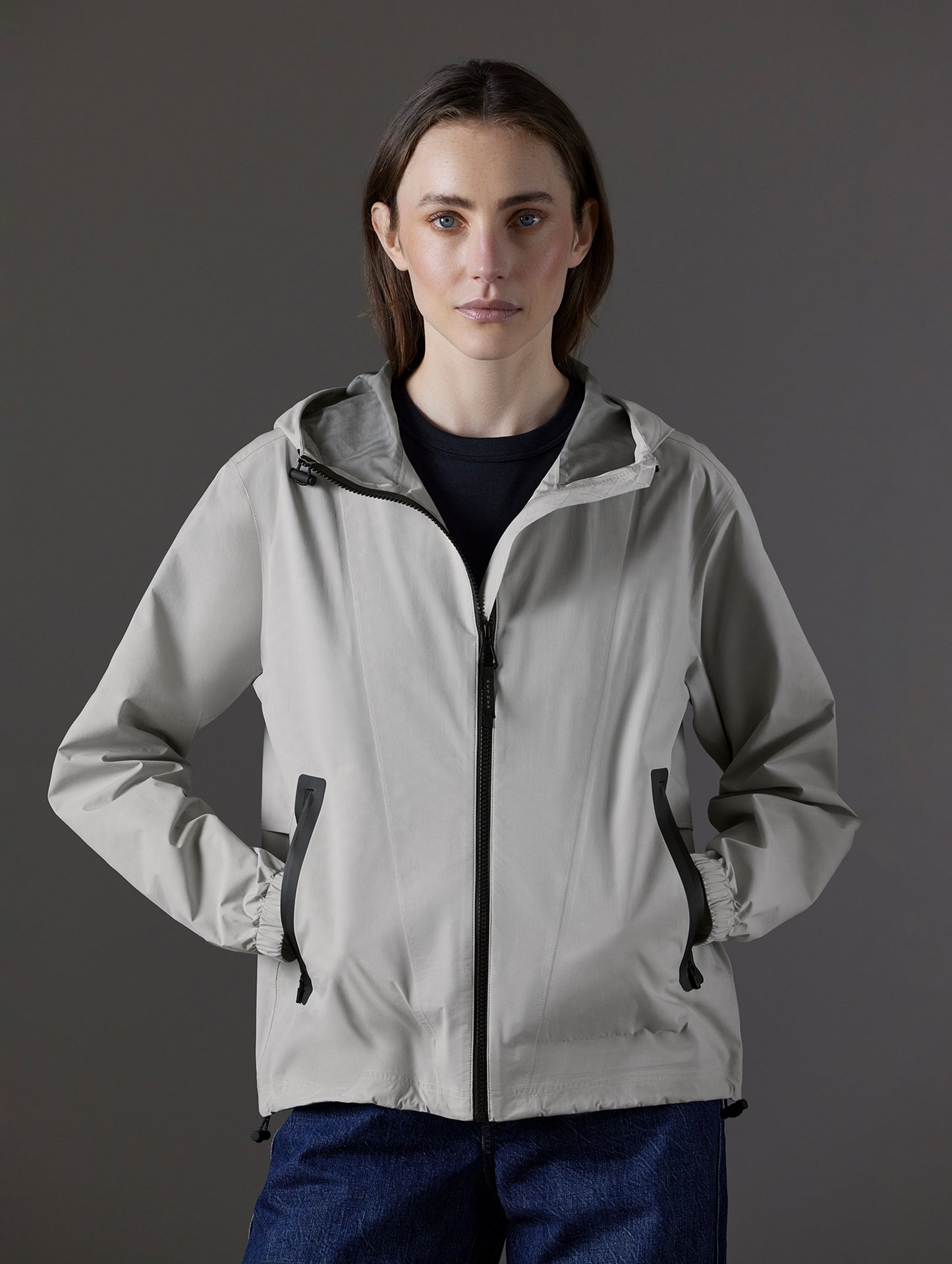 Front body view of woman wearing Kite Lightweight Jacket in Stone Grey from AETHER Apparel.