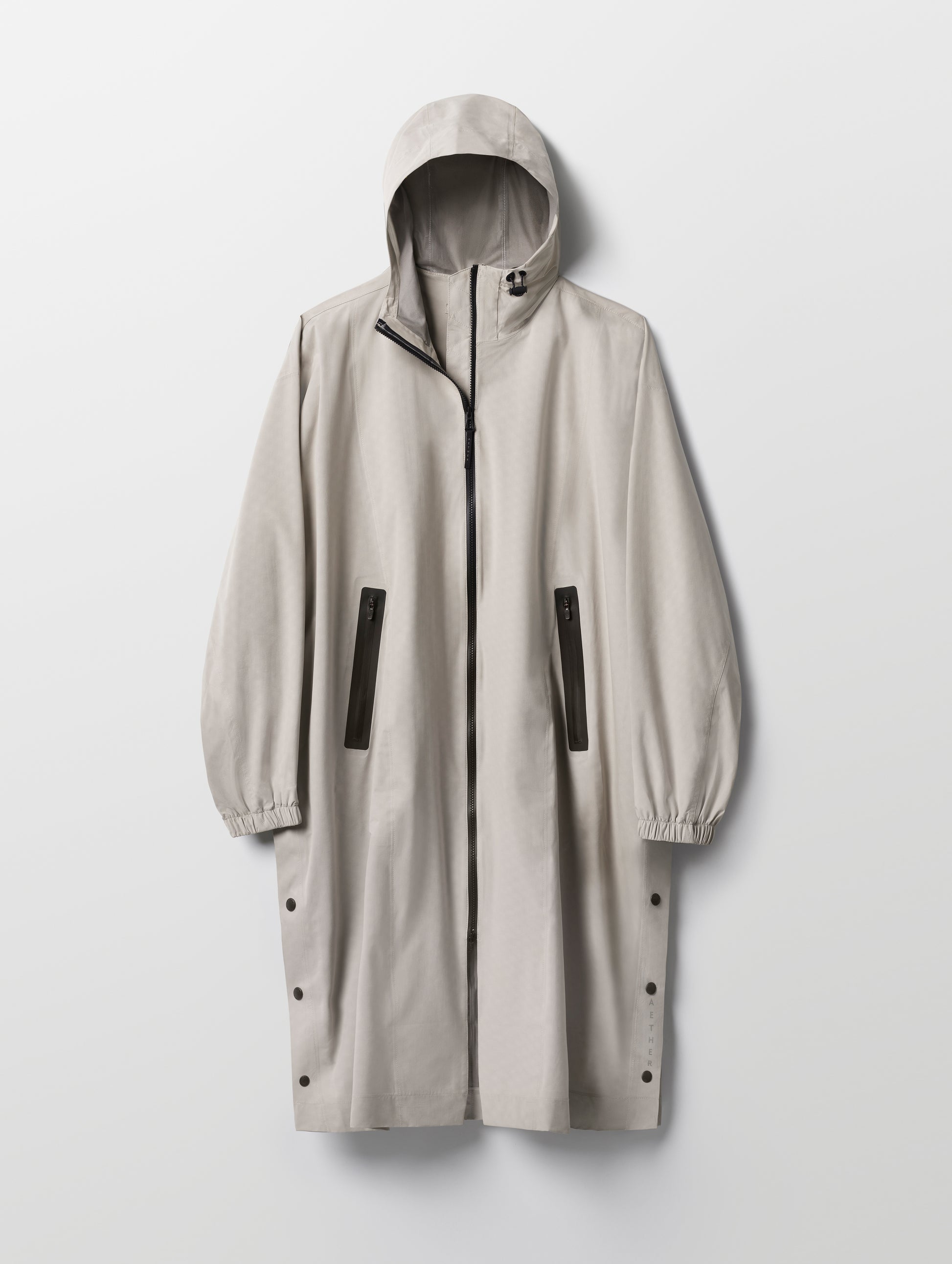Flat lay of the Kite Packable Rain Poncho in Stone Grey from AETHER Apparel.