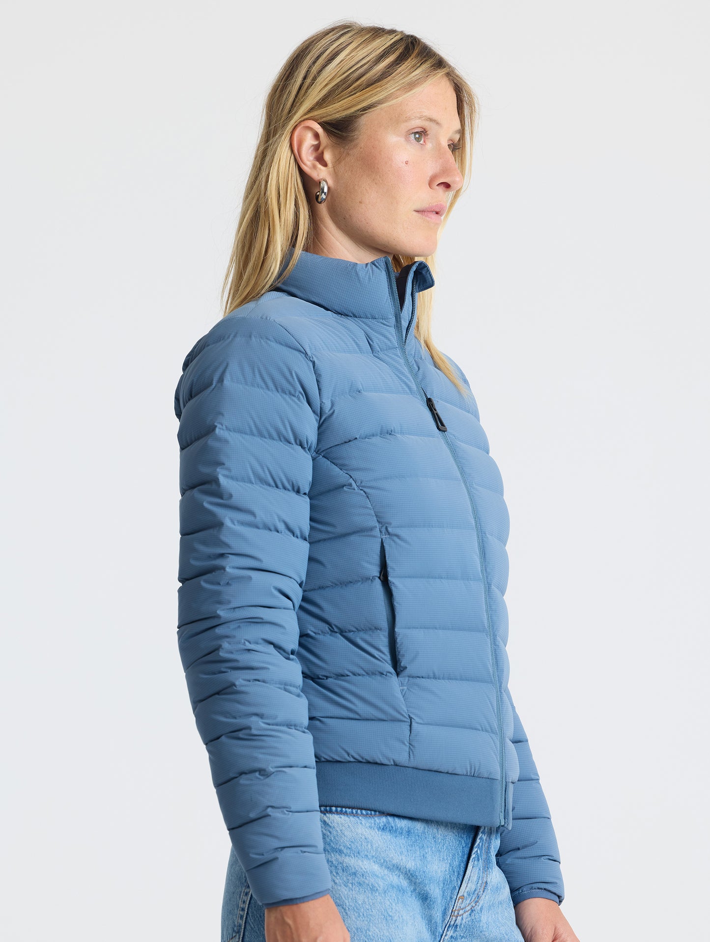 Angled view of woman wearing W Launch Full-Zip Jacket NH in Portal Blue from AETHER Apparel.