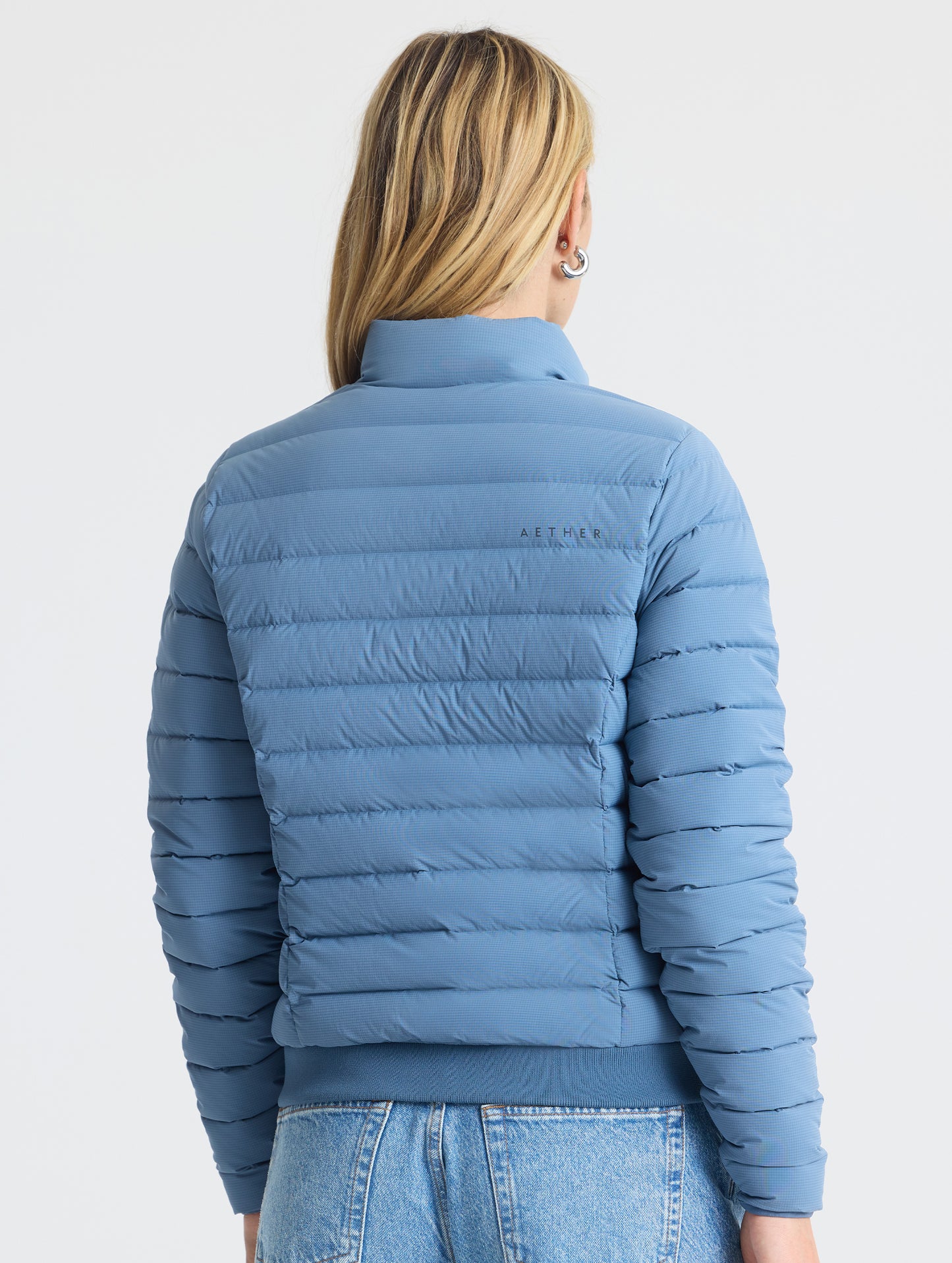 Rear view of woman wearing W Launch Full-Zip Jacket NH in Portal Blue from AETHER Apparel.
