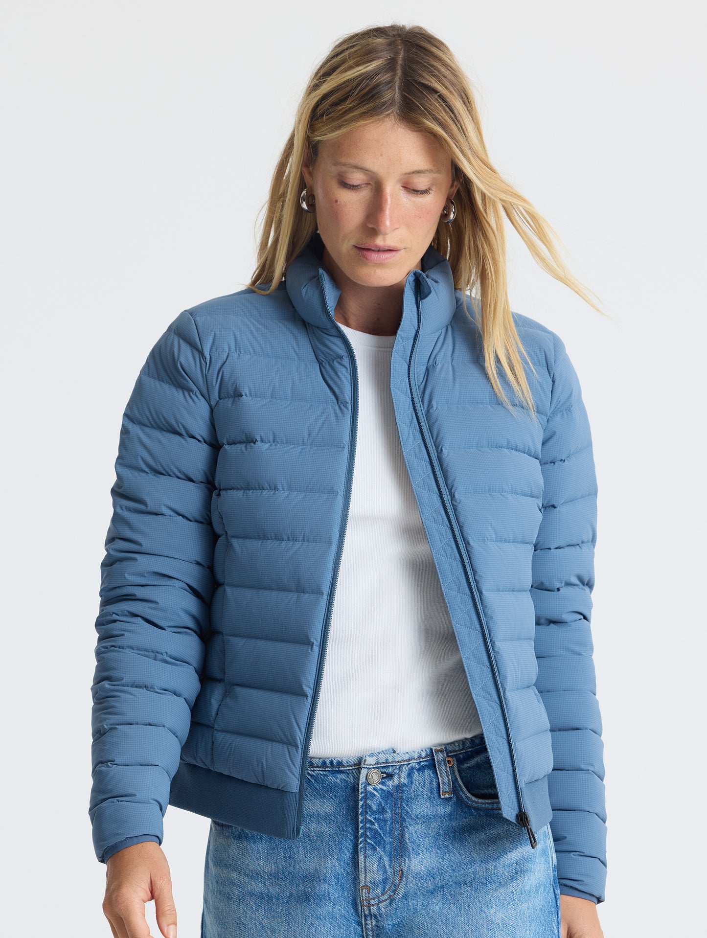 Front view of woman wearing unzipped W Launch Full-Zip Jacket NH in Portal Blue from AETHER Apparel.