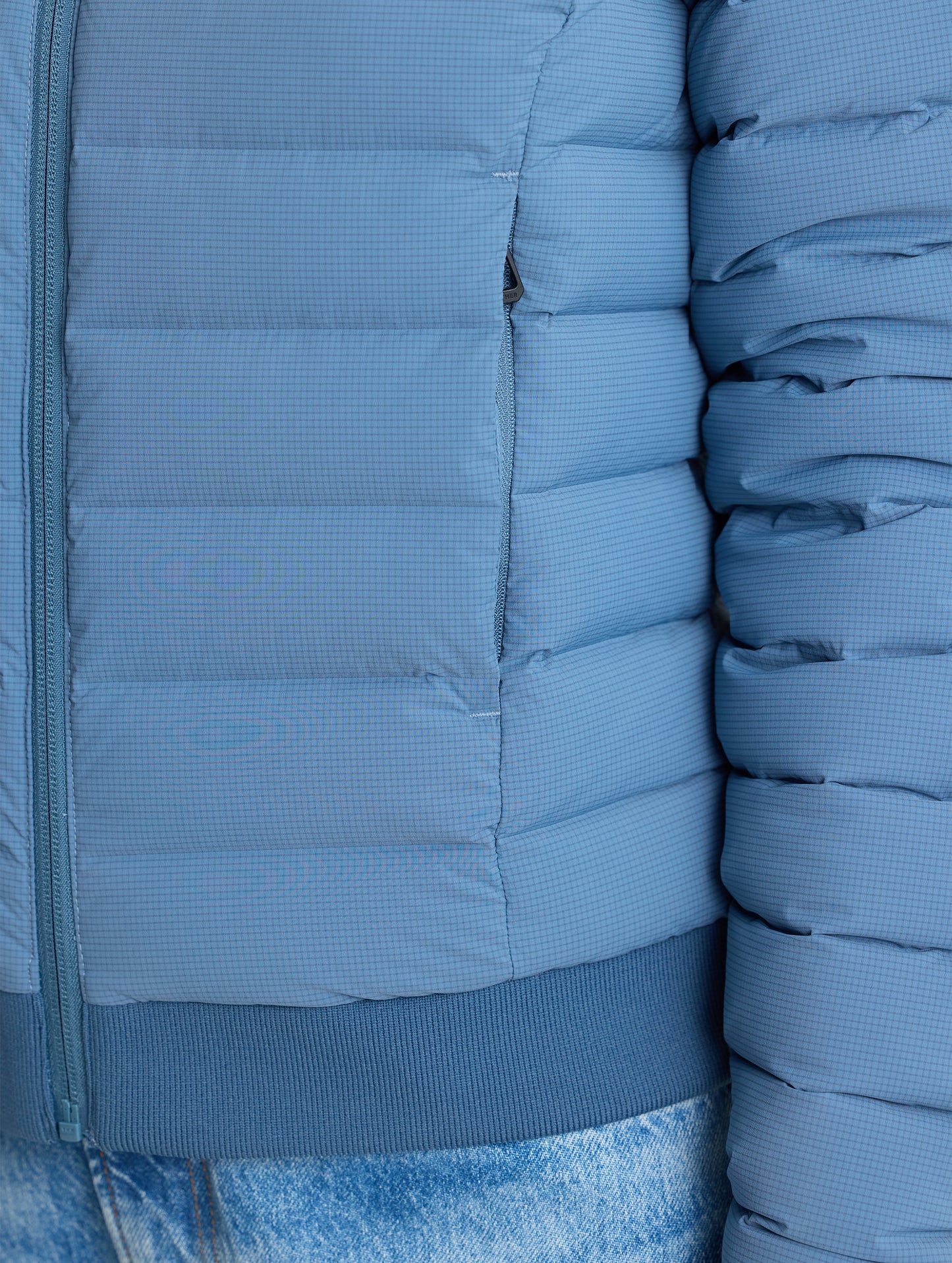 Closeup detail view of wearer's left pocket of W Launch Full-Zip Jacket NH in Portal Blue from AETHER Apparel.