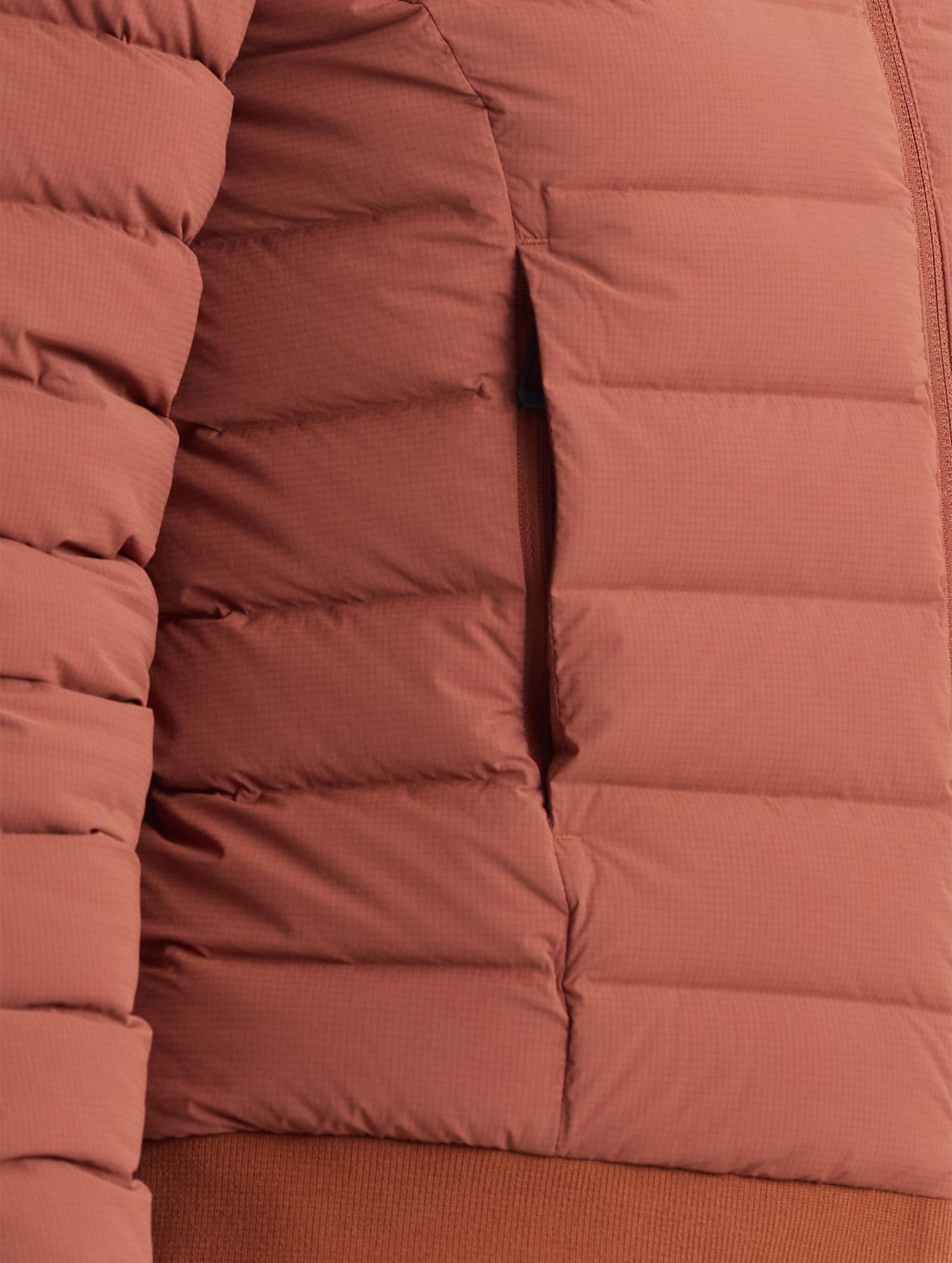 Closeup detail view of wearer's right pocket of W Launch Full-Zip Jacket NH in Redwood Rust from AETHER Apparel.