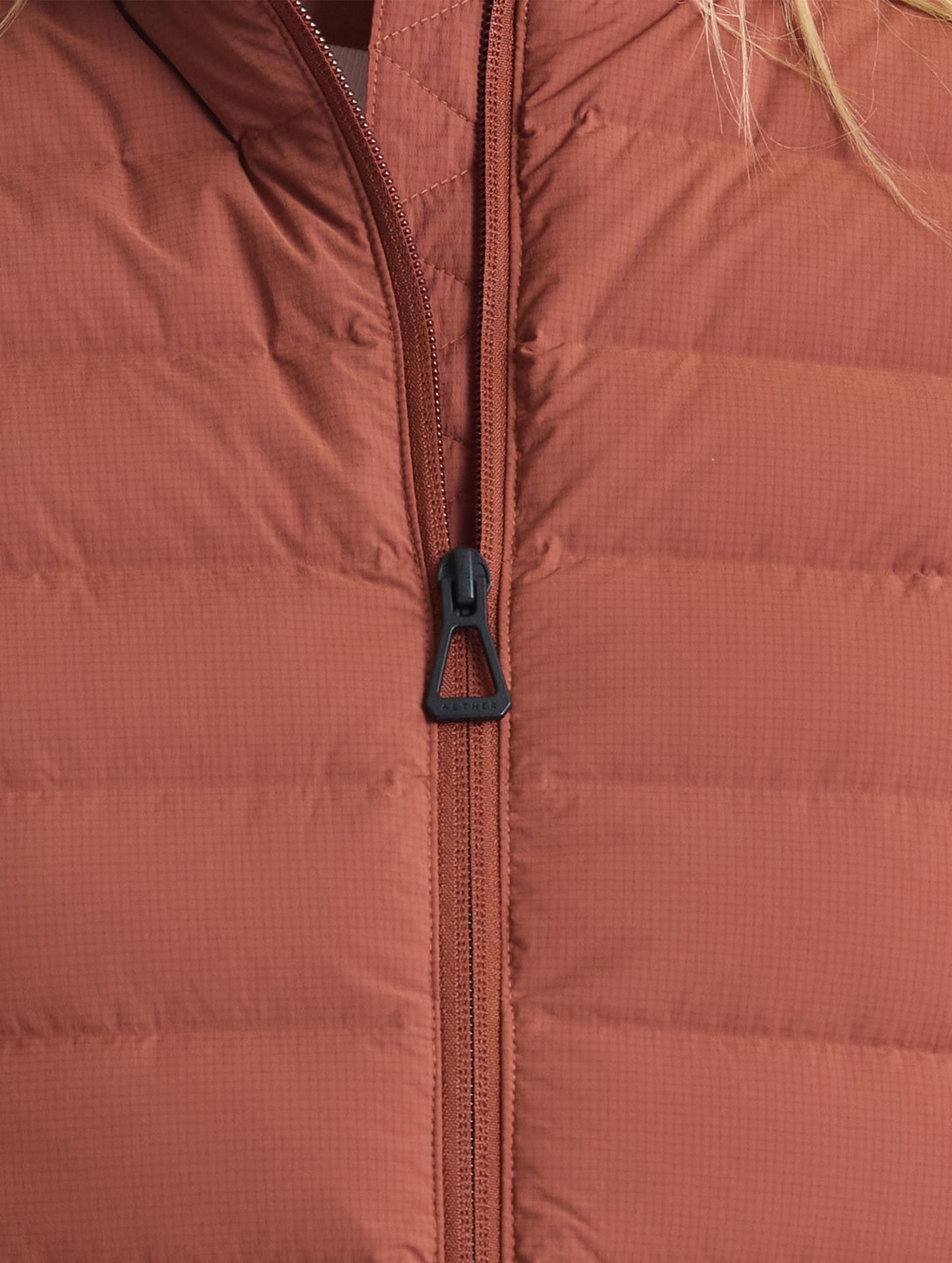 Closeup view of front zipper of W Launch Full-Zip Jacket NH in Redwood Rust from AETHER Apparel.