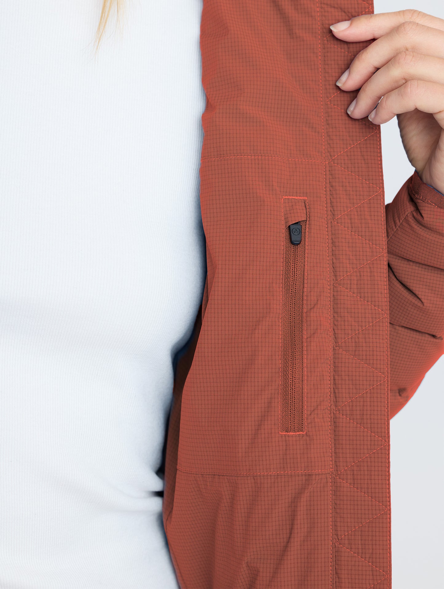 Closeup interior detail of left pocket of W Launch Full-Zip Jacket NH in Redwood Rust from AETHER Apparel.