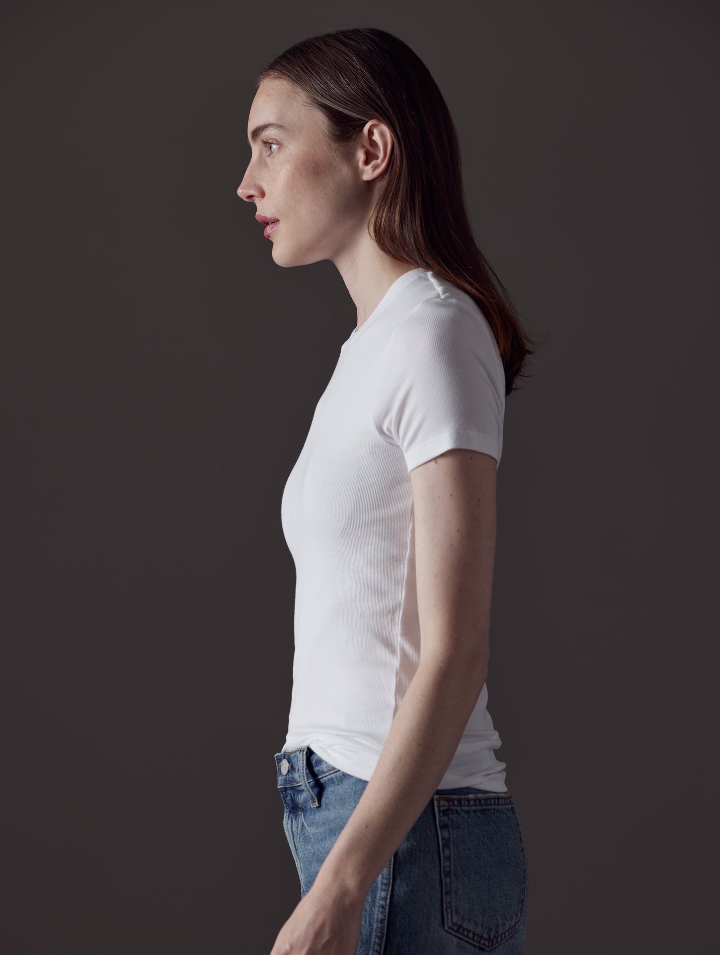 Side profile view of woman wearing Legacy Short-Sleeve Crew in White from AETHER Apparel.