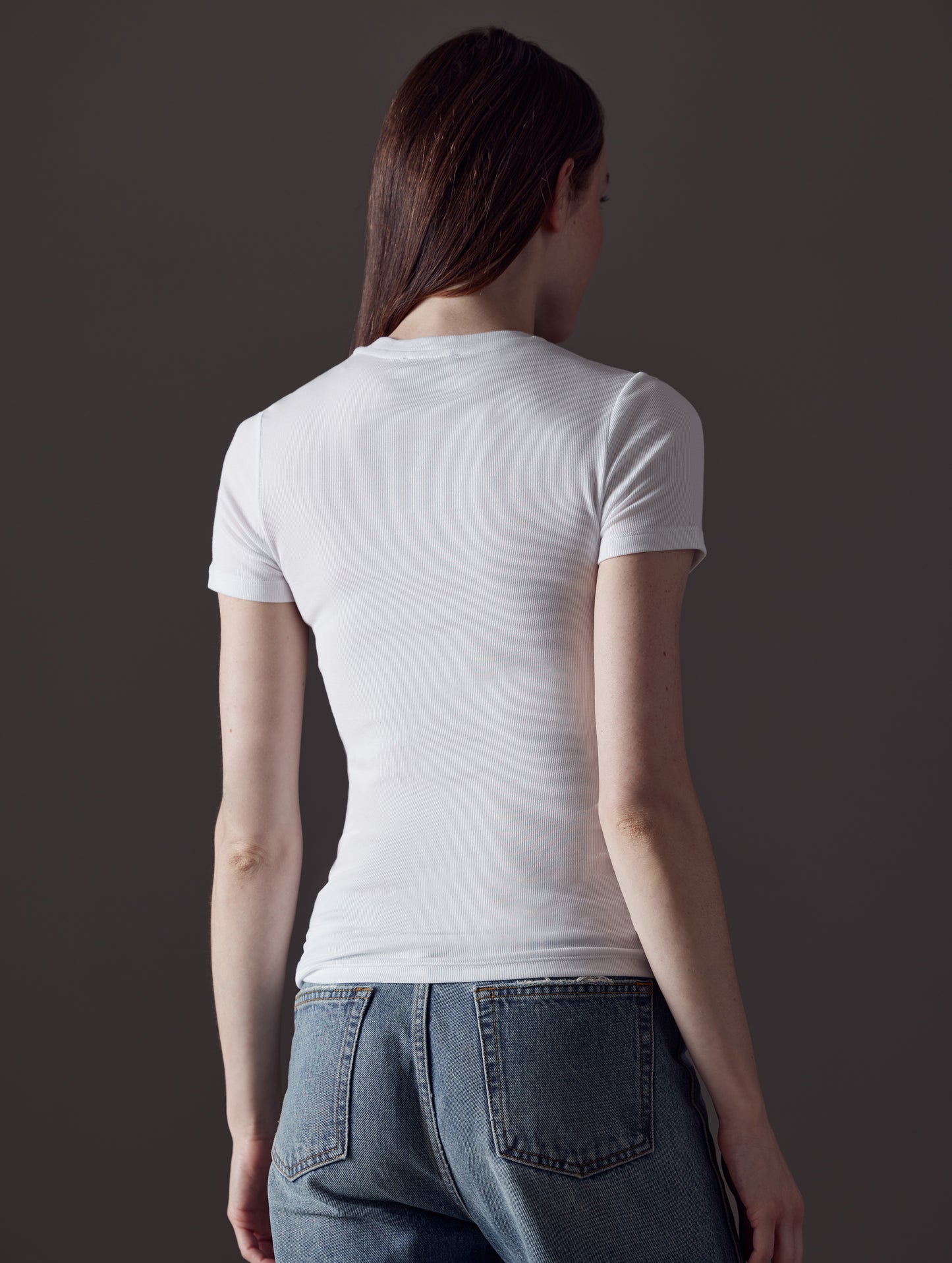Rear angled view of woman wearing Legacy Short-Sleeve Crew in White from AETHER Apparel.
