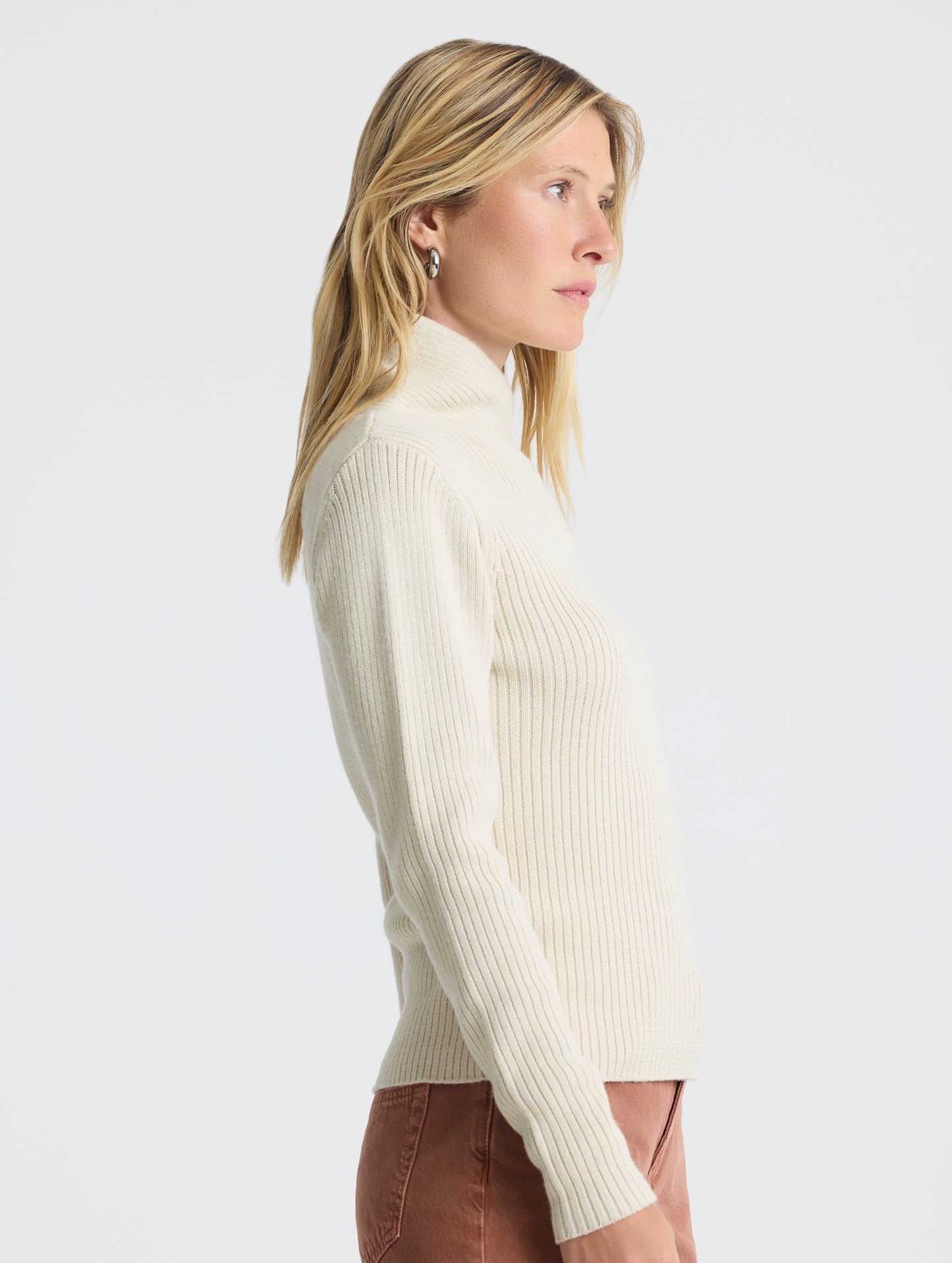 Right profile view of woman wearing Lexington Sweater in Bone white from AETHER Apparel.