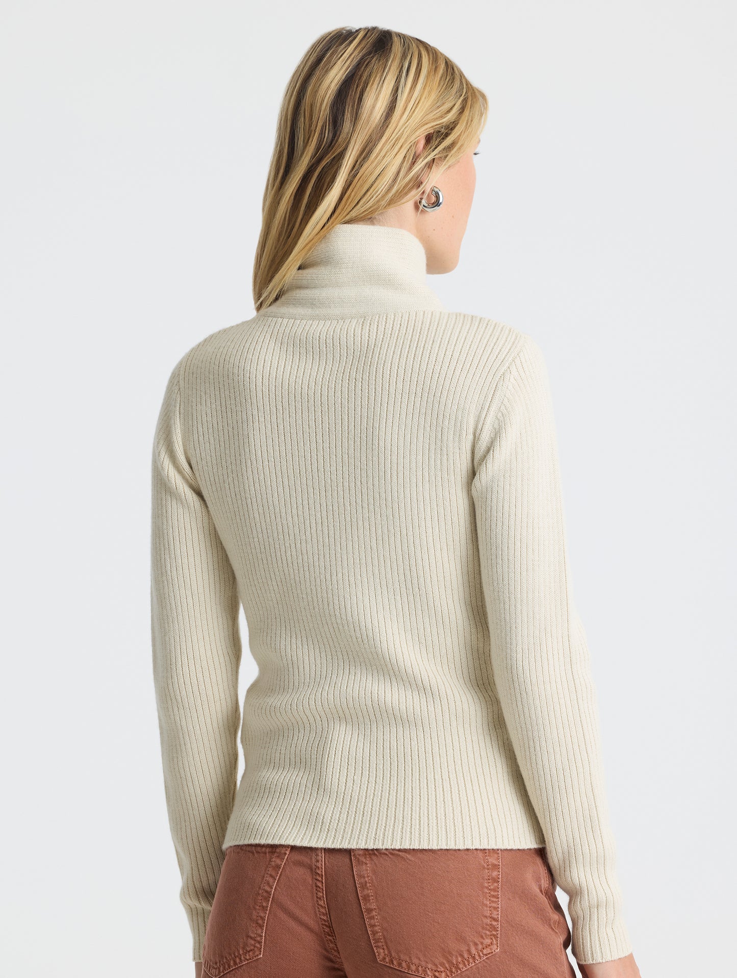 Angled rear view of woman wearing Lexington Sweater in Bone white from AETHER Apparel.