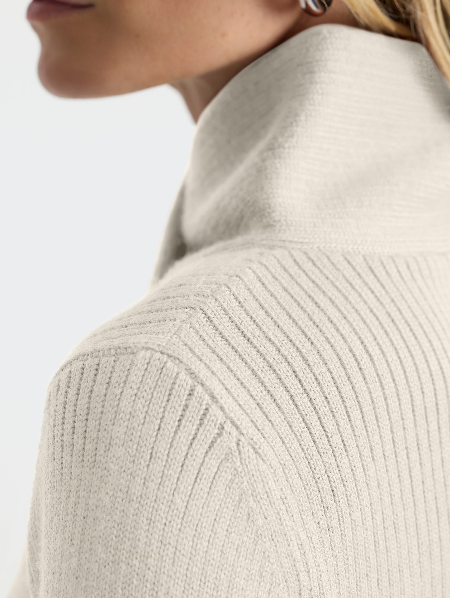 Closeup detail view of wearer's left shoulder stitch of Lexington Sweater in Bone white from AETHER Apparel.