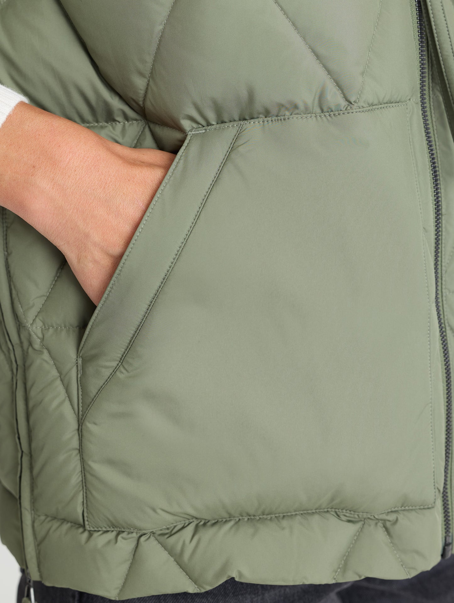 Closeup of wearer's right hand pocket of Mailen Oversized Vest in Fern Green from AETHER Apparel.
