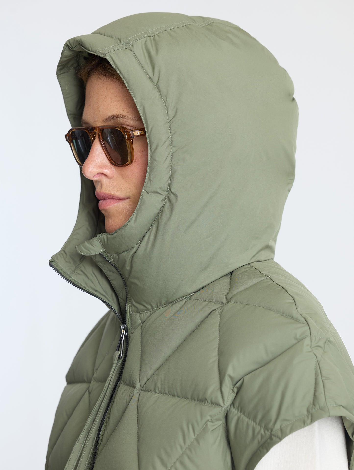 Women wearing hood of Mailen Oversized Vest in Fern Green from AETHER Apparel.