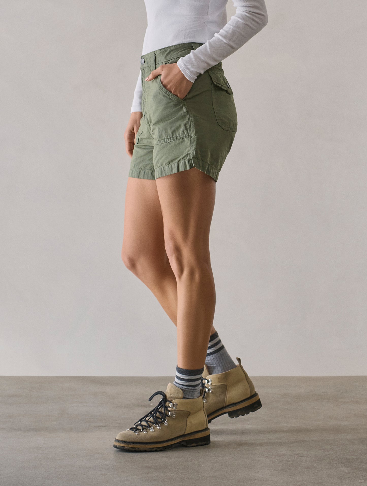 Side profile lower body view of woman wearing Masai Safari Short in Fern Green from AETHER Apparel.