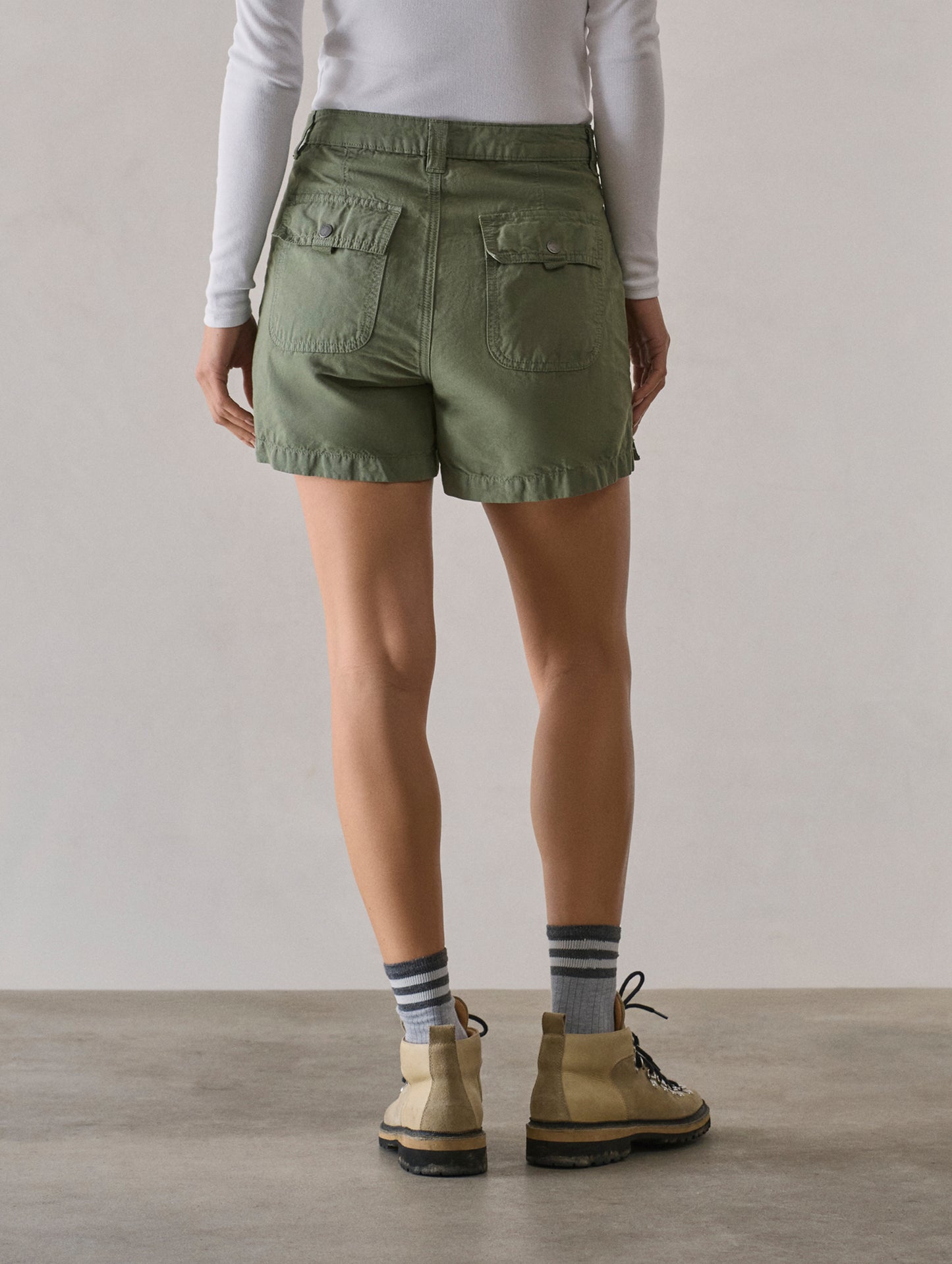 Rear lower body view of woman wearing Masai Safari Short in Fern Green from AETHER Apparel.