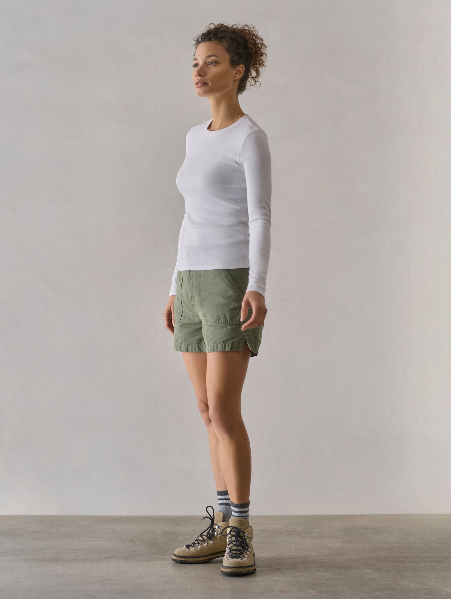 Front 3/4 full body view of woman wearing Masai Safari Short in Fern Green from AETHER Apparel.