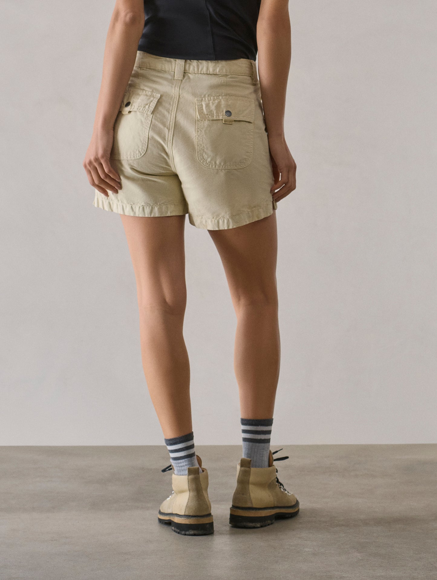 Rear lower body view of woman wearing Masai Safari Short in Bone white from AETHER Apparel.