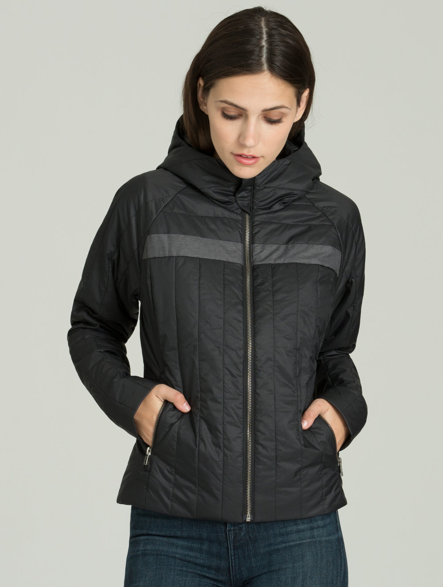 Woman wearing black Nell Jacket with hands in pockets from AETHER Apparel.