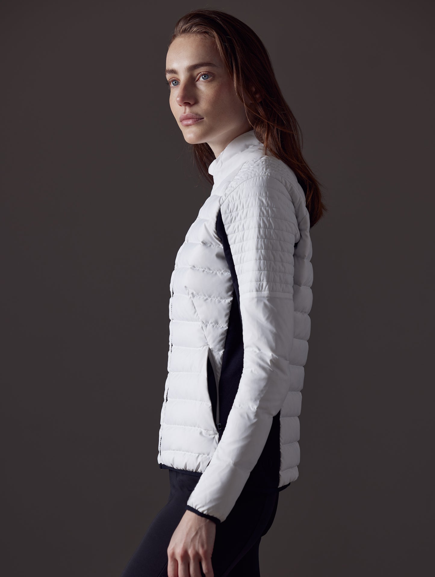 Side profile view of woman wearing Ozone Jacket in White from AETHER Apparel.