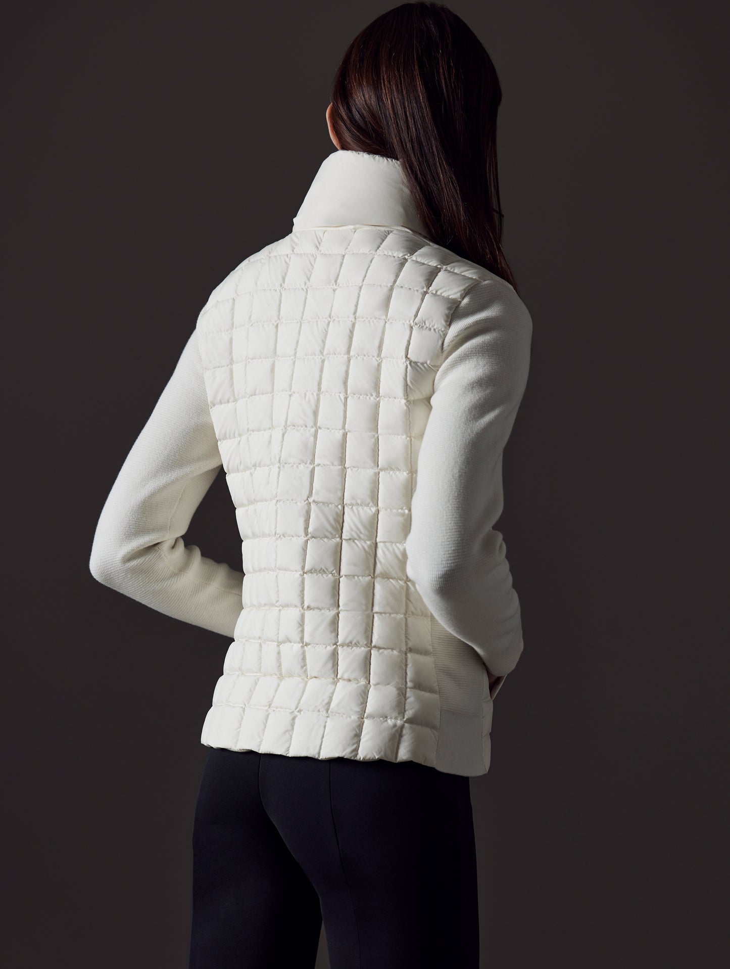 Rear angled view of woman wearing Phase Full-Zip in Winter White from AETHER Apparel.