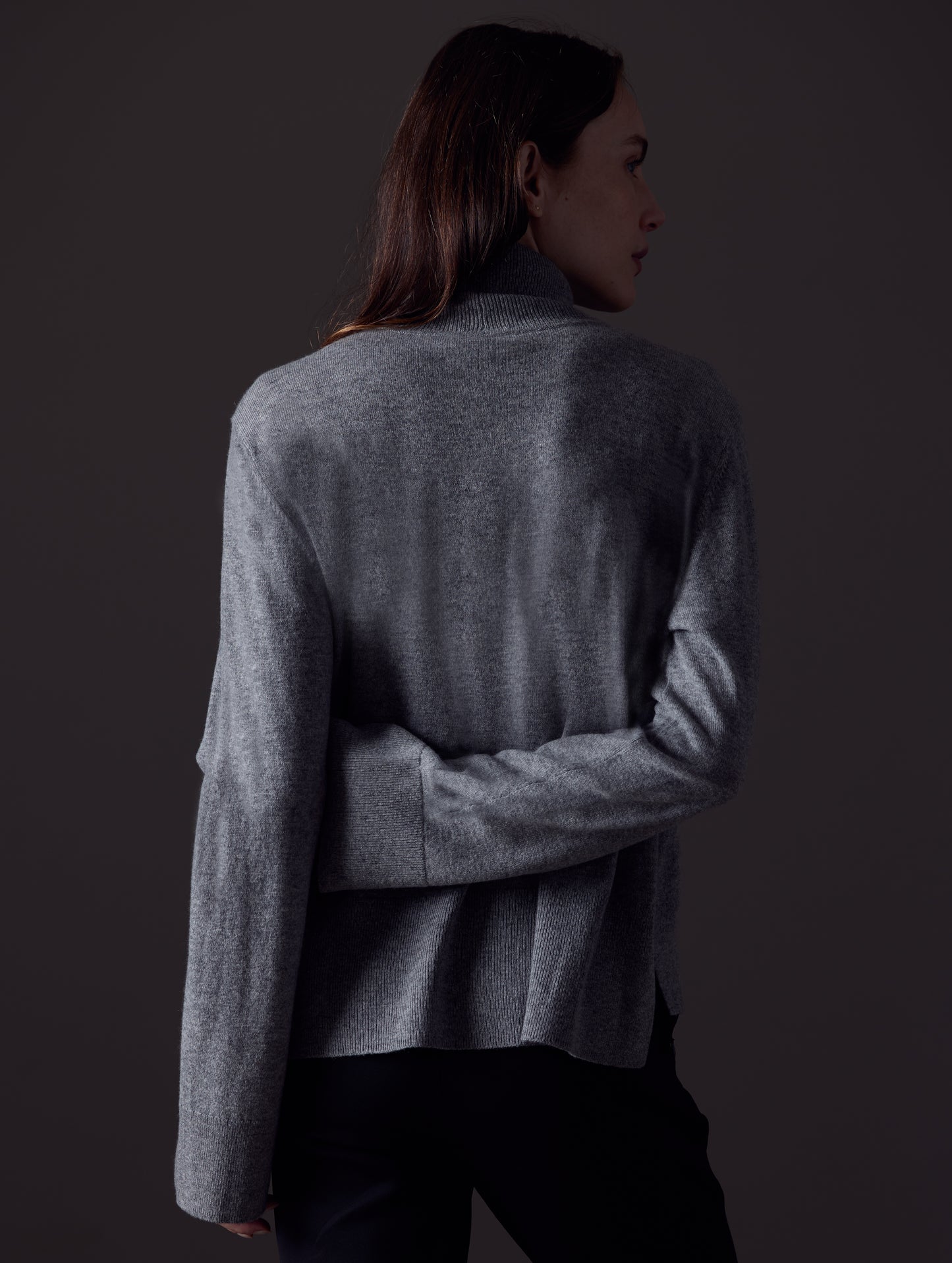 Rear view of woman wearing Leigh Cashmere Turtleneck Sweater in Heather Grey from AETHER Apparel.