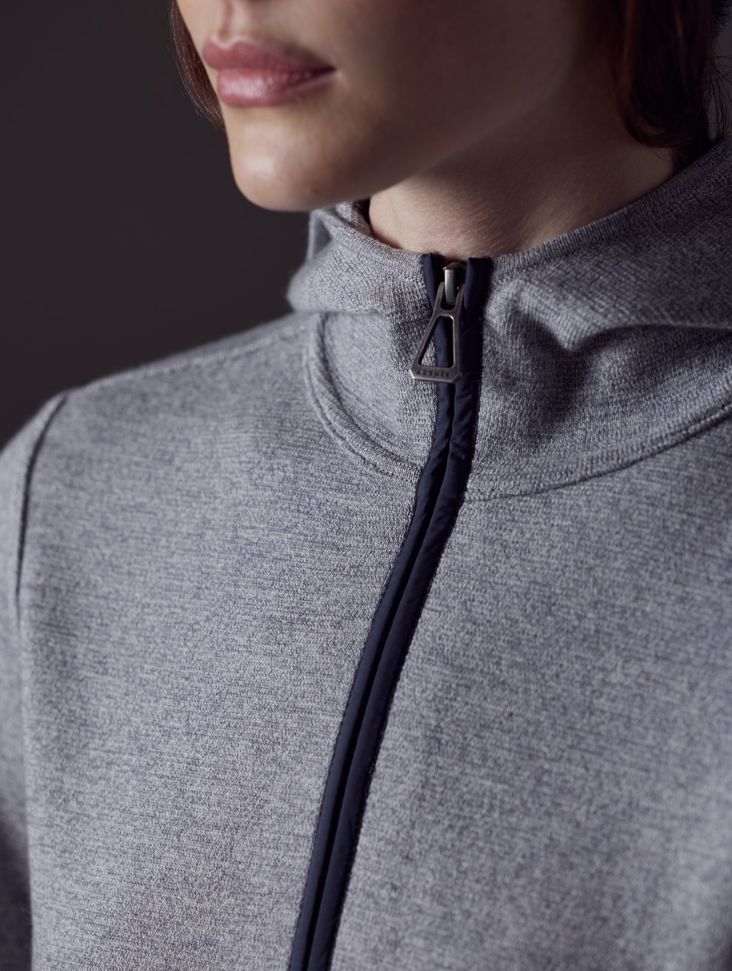 Closeup detailed view of collar and main zipper on women's Riley Full-Zip Sweater in Light Heather Grey from AETHER Apparel.