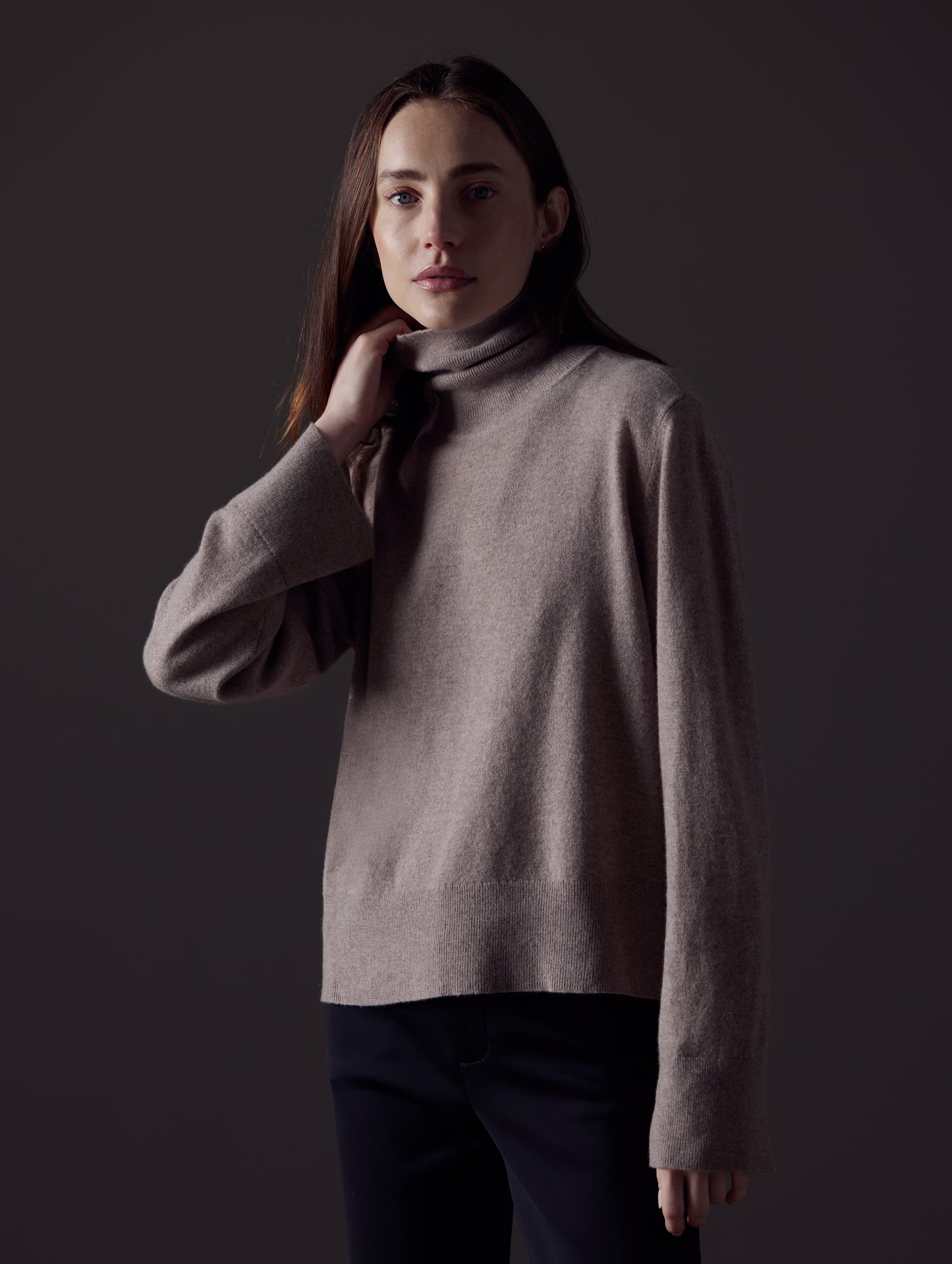Front angled view of woman wearing Leigh Cashmere Turtleneck Sweater in Toast Brown from AETHER Apparel.