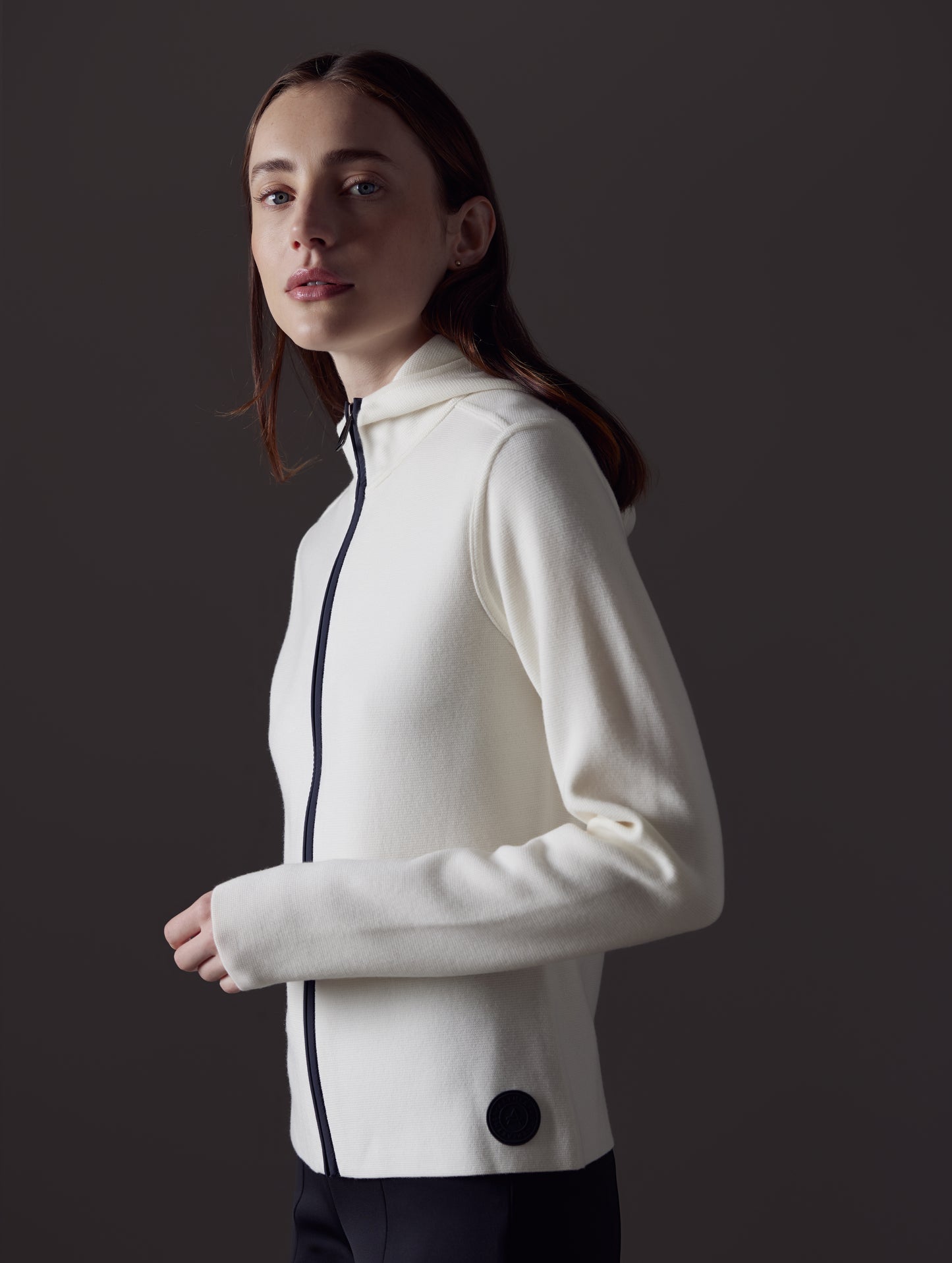 Side profile view of woman wearing Riley Full-Zip Sweater in Winter White from AETHER Apparel.