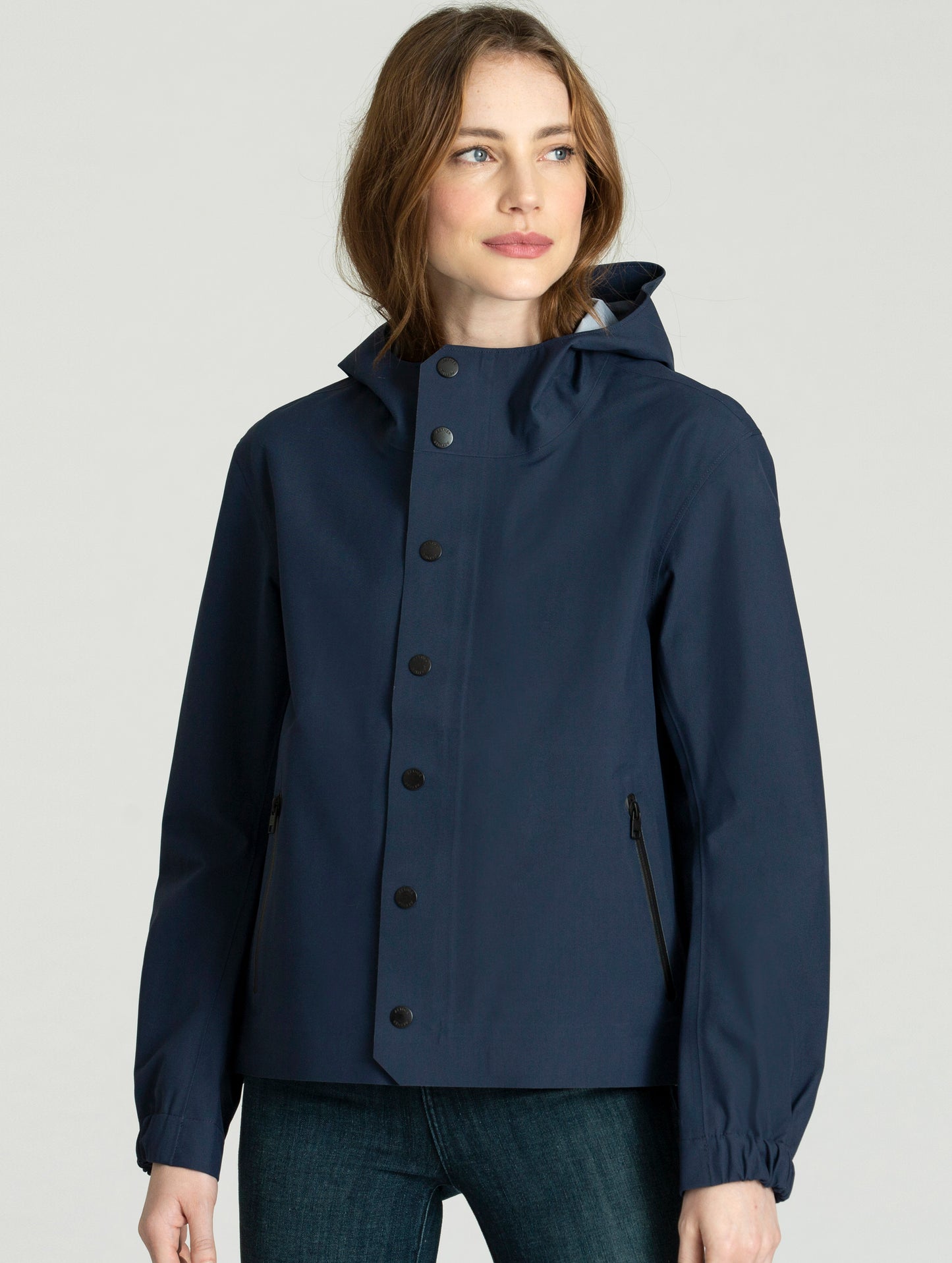 Woman wearing fully buttoned blue Seattle Jacket from AETHER Apparel.