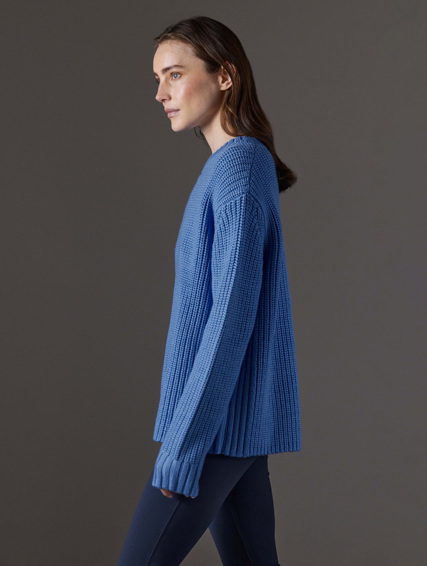 Side profile view of woman wearing Sherwood Crewneck Sweater in Lavender Blue from AETHER Apparel.