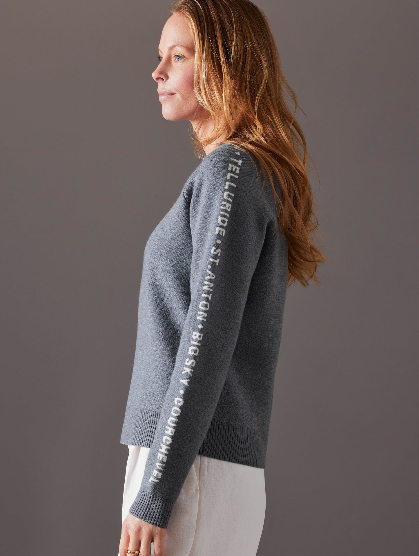 Side profile view of woman wearing Ski Town Sweater in Heather Grey from AETHER Apparel.