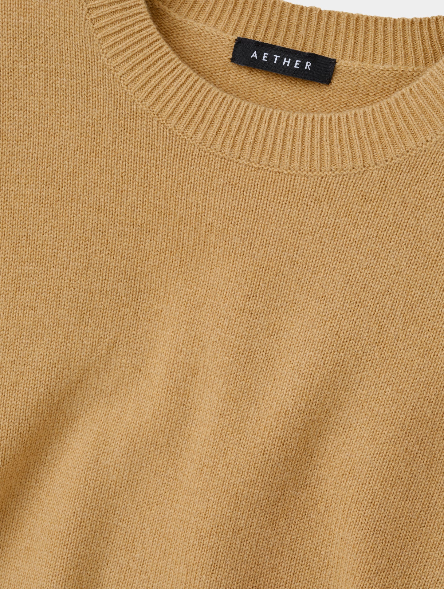 Closeup detailed view of the rib-knit collar and main body construction on the Solace Cashmere Sweater in Latte Brown from AETHER Apparel.