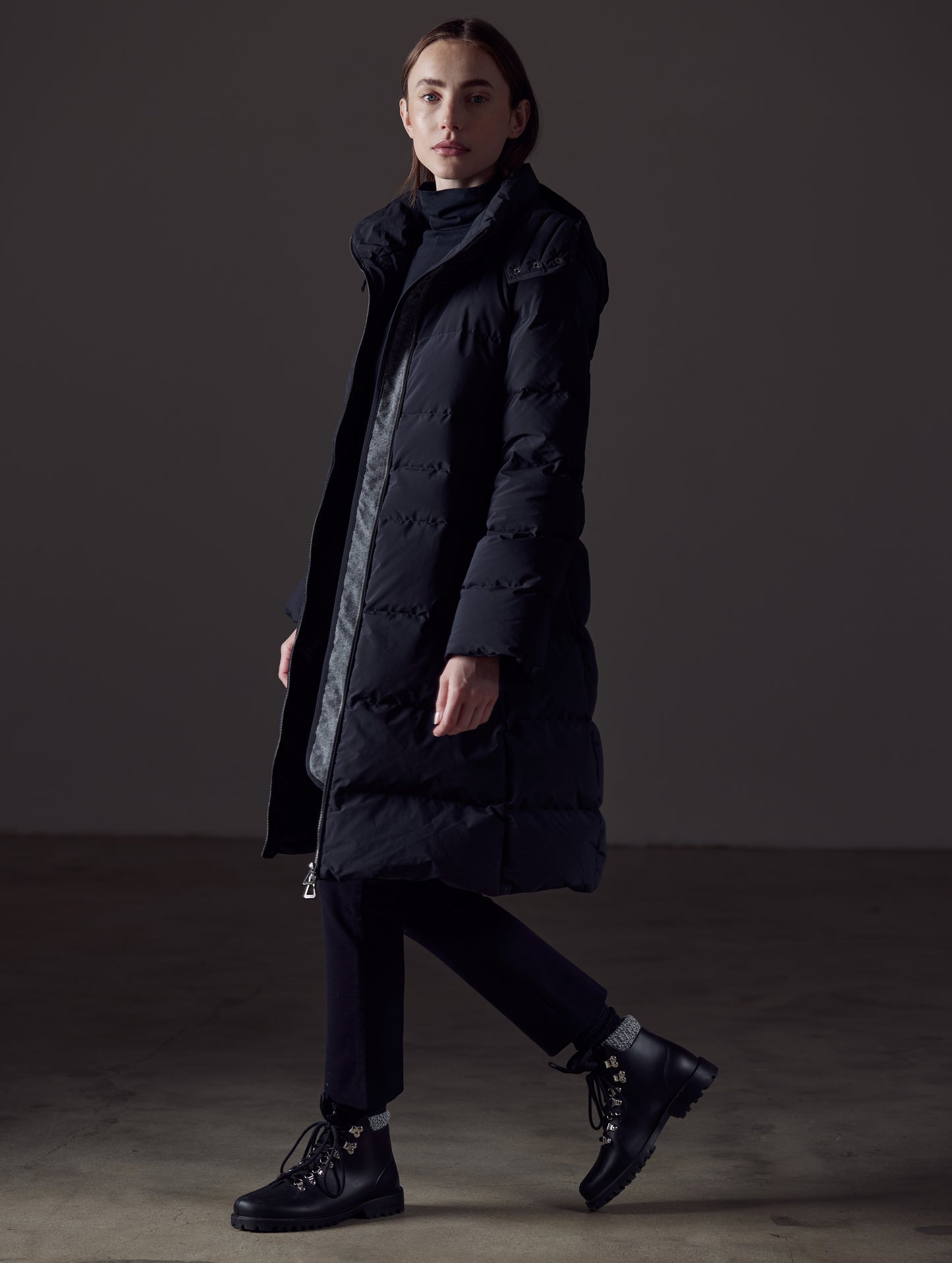 Side profile full-body view of woman wearing Stirling Jacket in Onyx Black from AETHER Apparel.