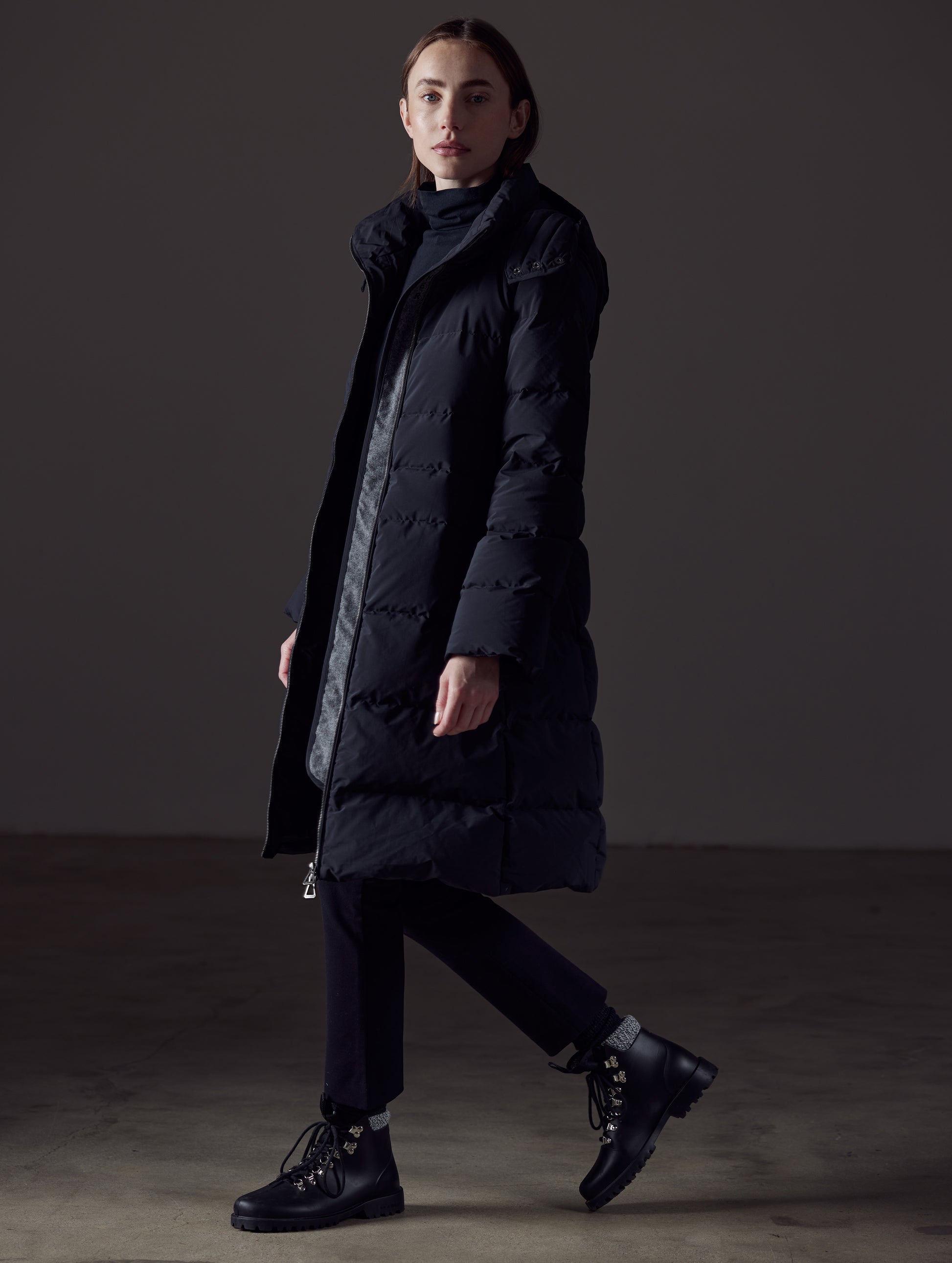 Side profile full-body view of woman wearing Stirling Jacket in Onyx Black from AETHER Apparel.