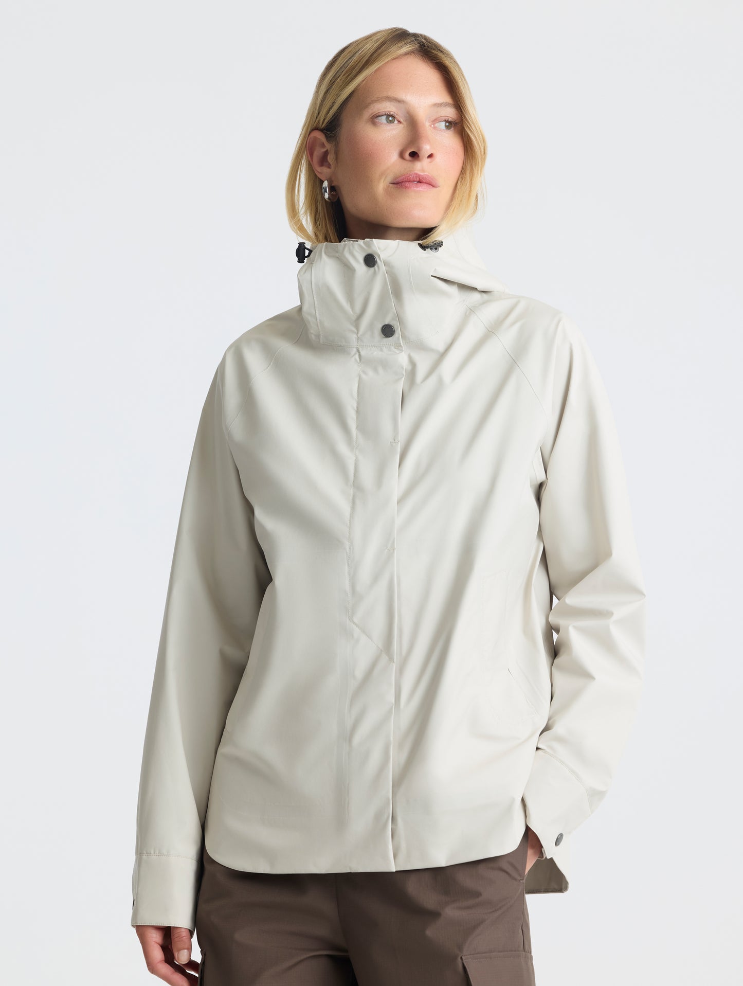 Front view of woman wearing Storm All-Weather Jacket in Bone white from AETHER Apparel.