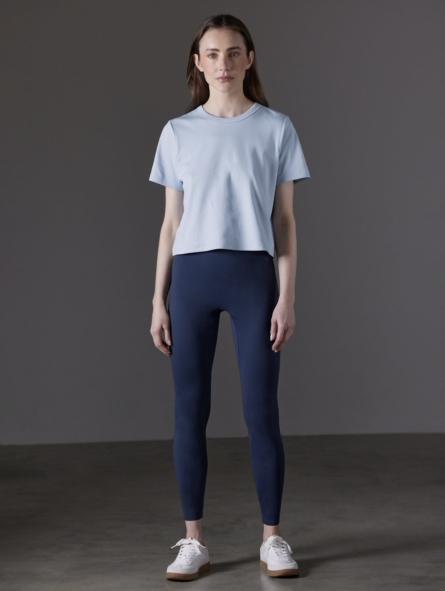 Front full-body view of woman wearing Winter Legging 2.0 in Nordic Navy blue from AETHER Apparel.