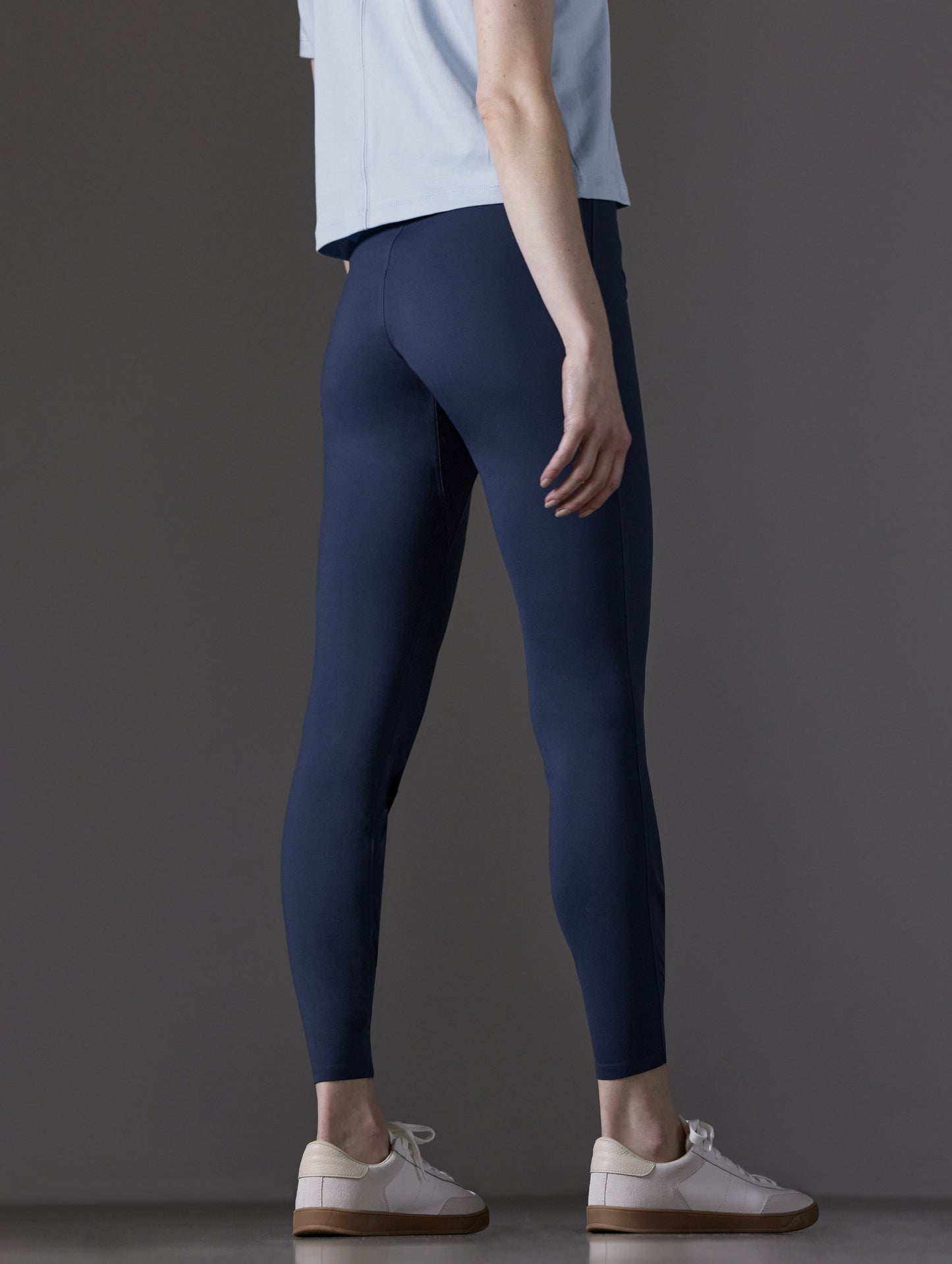 Rear angled lower body view of woman wearing Winter Legging 2.0 in Nordic Navy blue from AETHER Apparel.