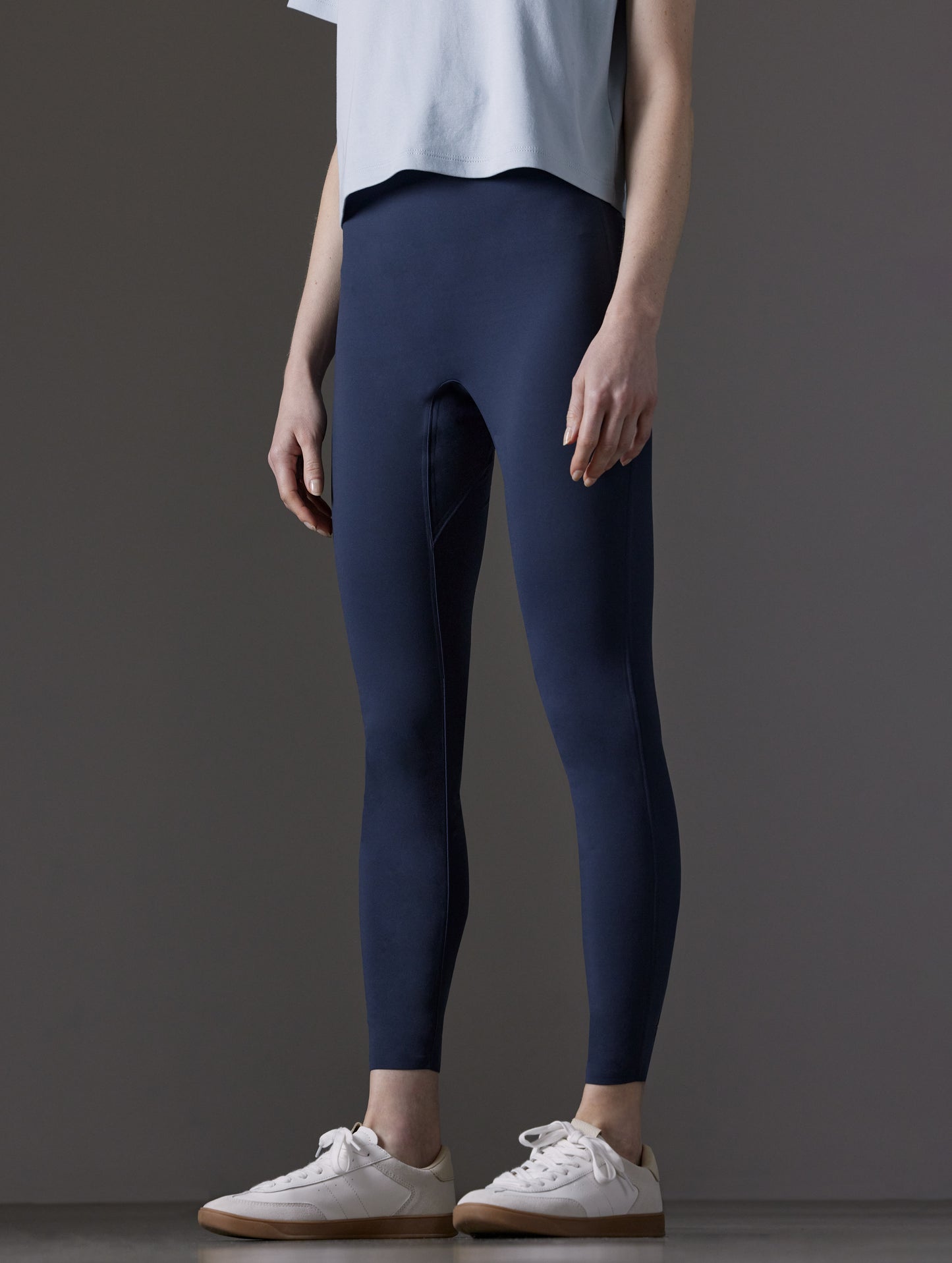 Front angled lower body view of woman wearing Winter Legging 2.0 in Nordic Navy blue from AETHER Apparel.