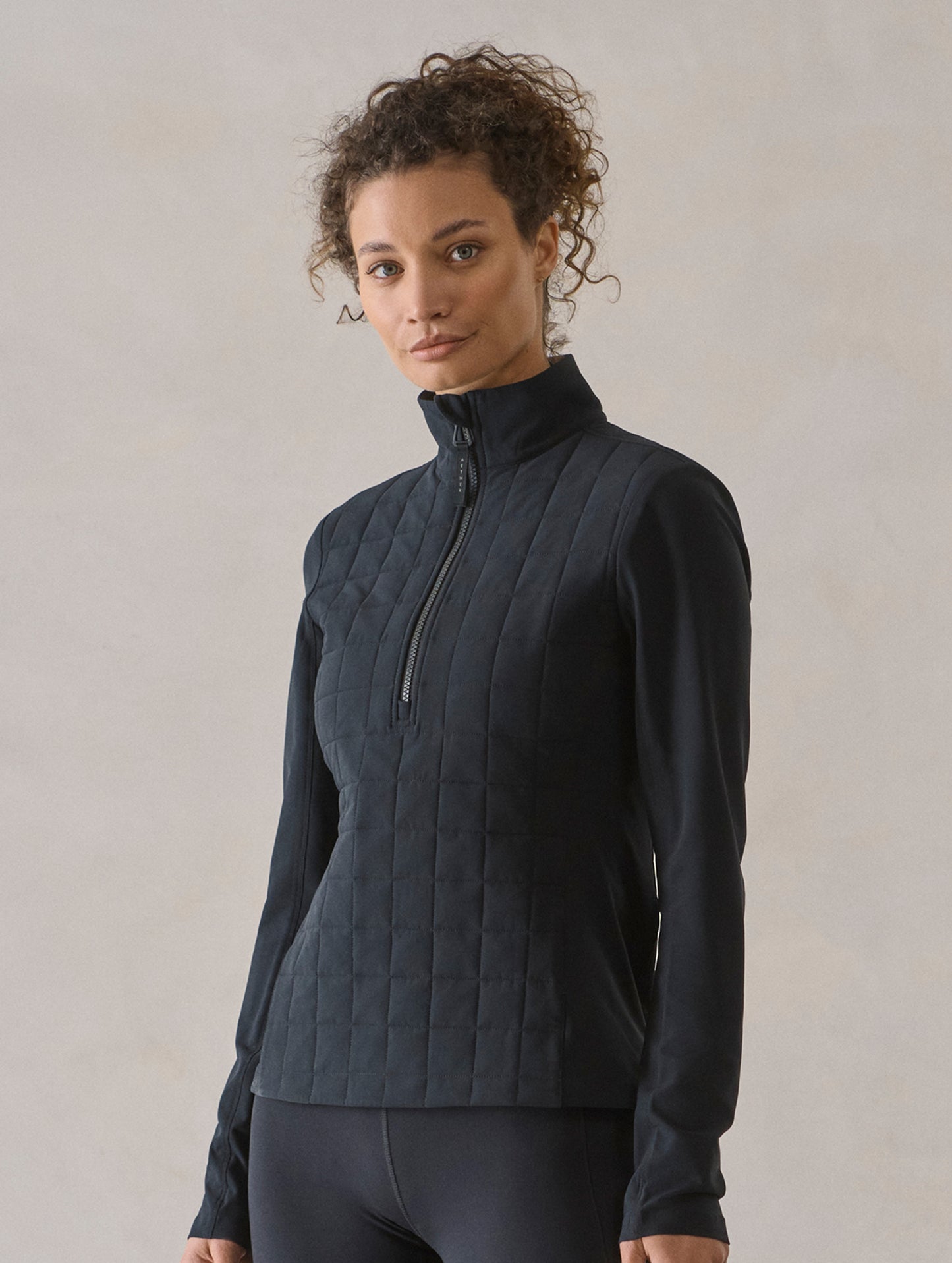 Front 3/4 body view of woman wearing Wren Insulated Half-Zip in Onyx Black from AETHER Apparel.