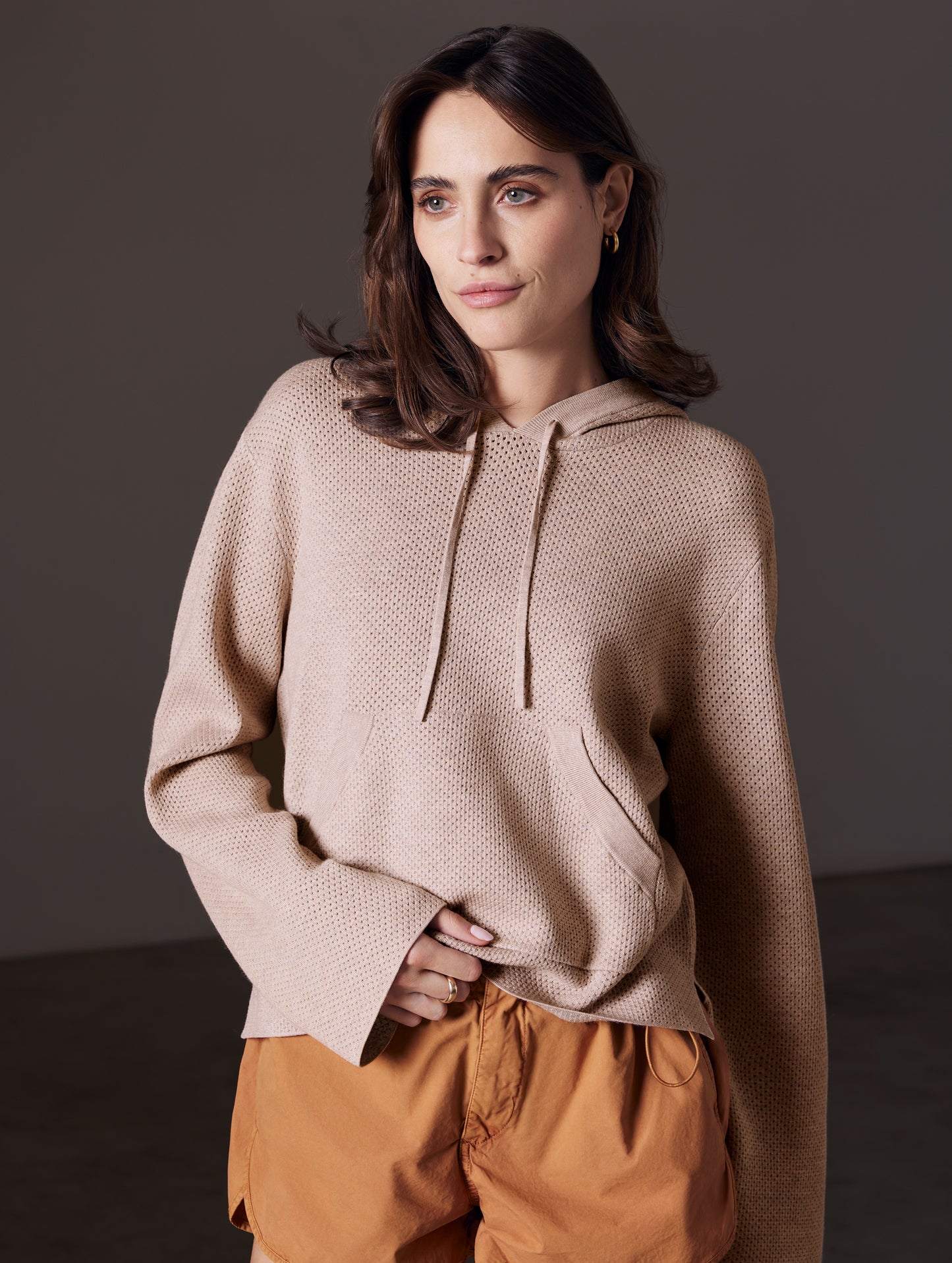 Front view of woman wearing Baja Mesh Sweater in Desert Beige from AETHER Apparel.