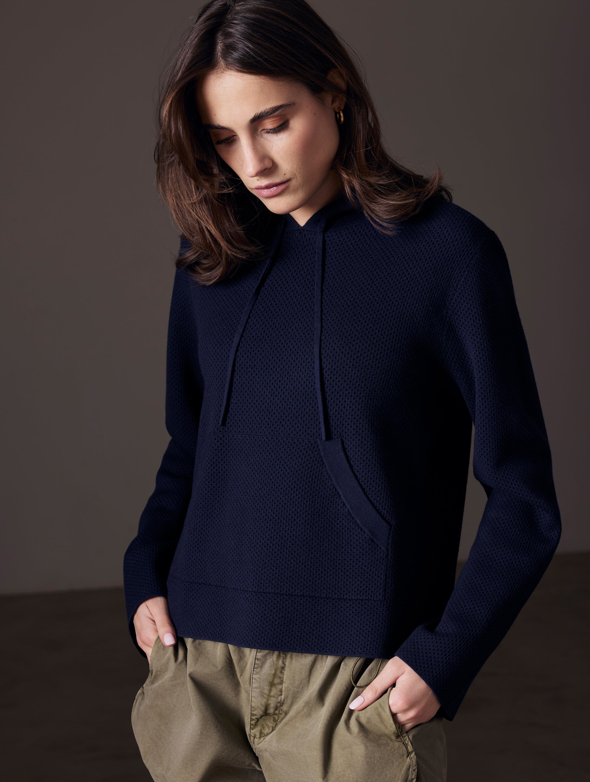 Front angled view of woman wearing Baja Mesh Sweater in Total Eclipse dark blue from AETHER Apparel.